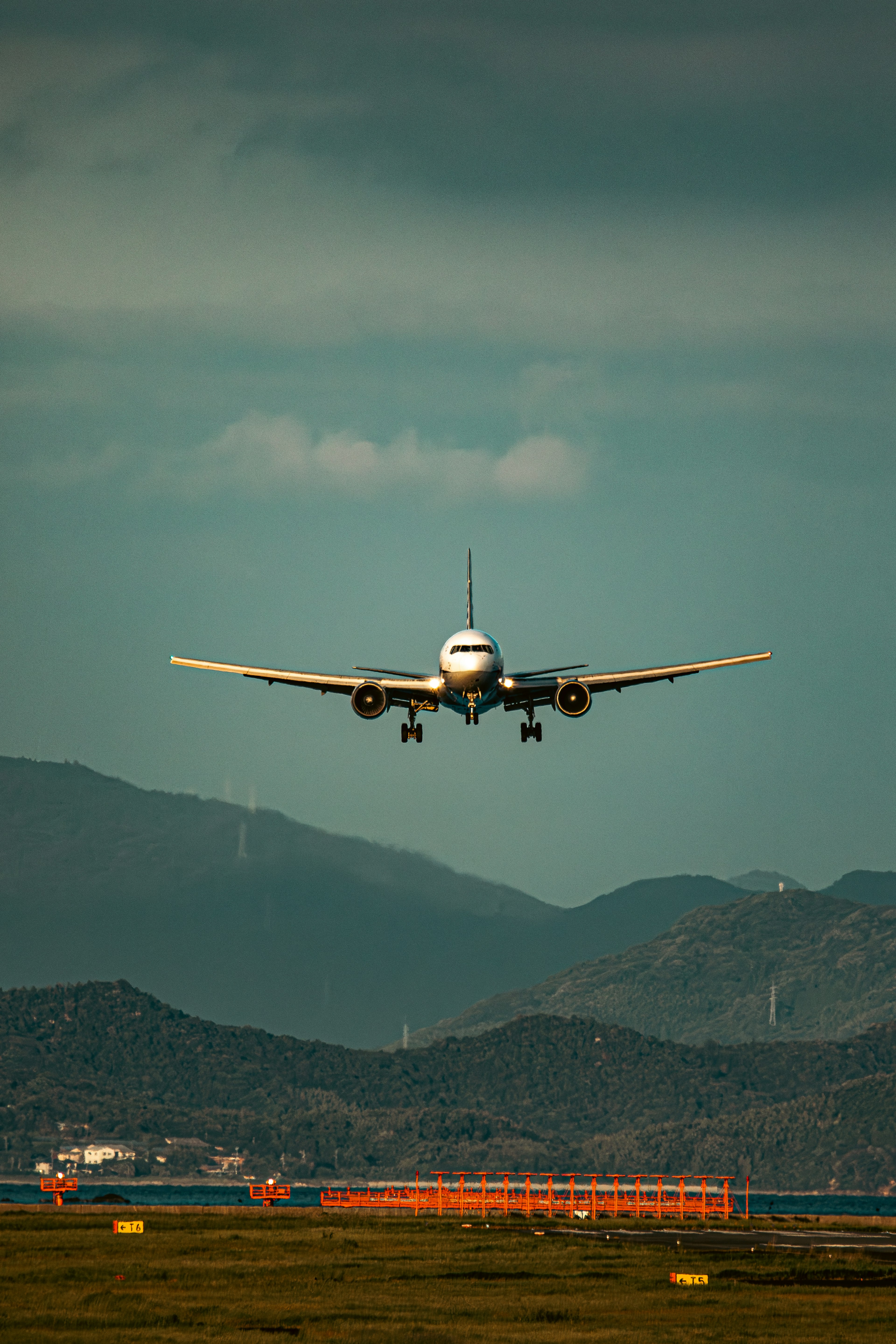 Avión aterrizando en un aeropuerto con montañas de fondo