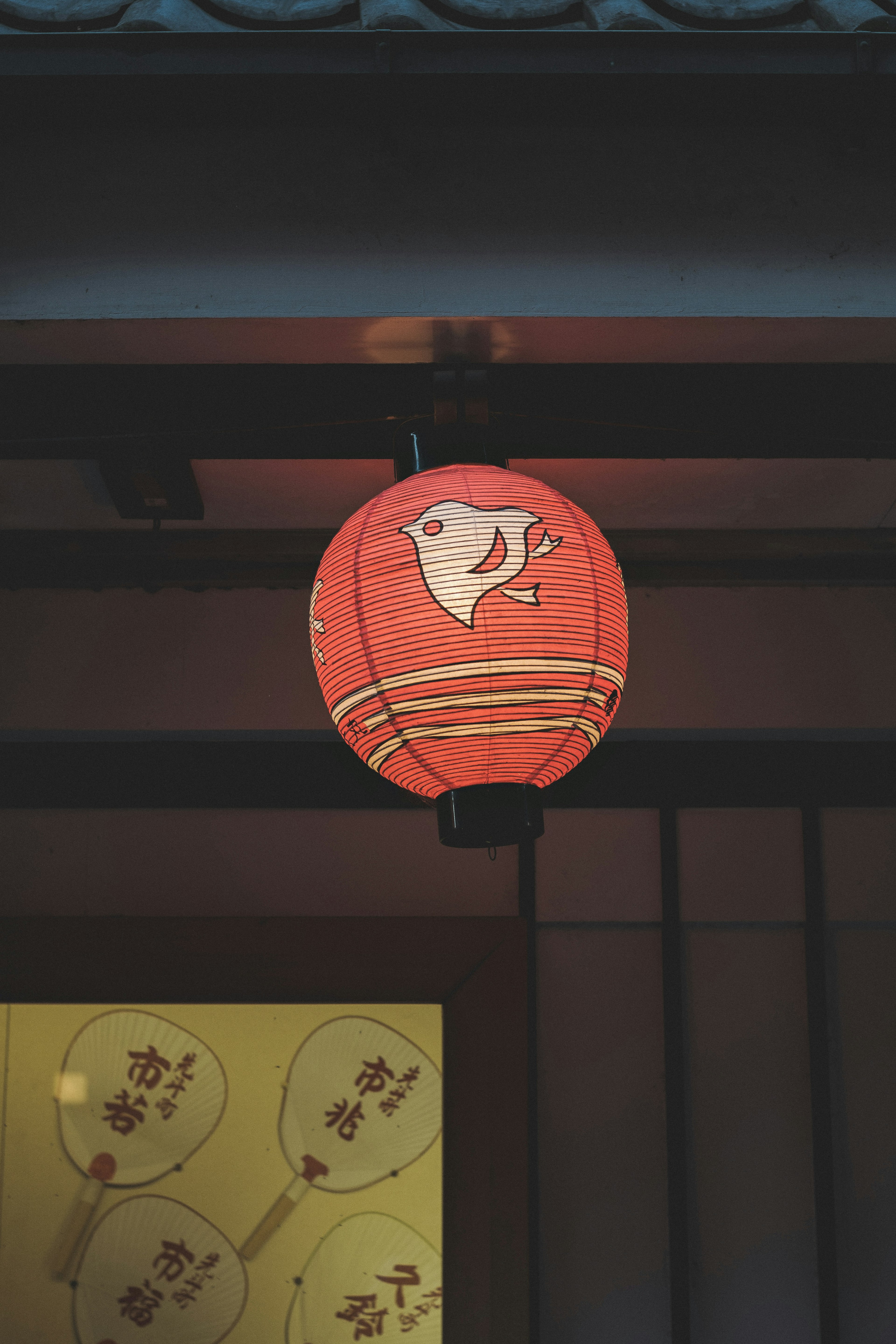 Traditional Japanese lantern featuring a fish design in vibrant red