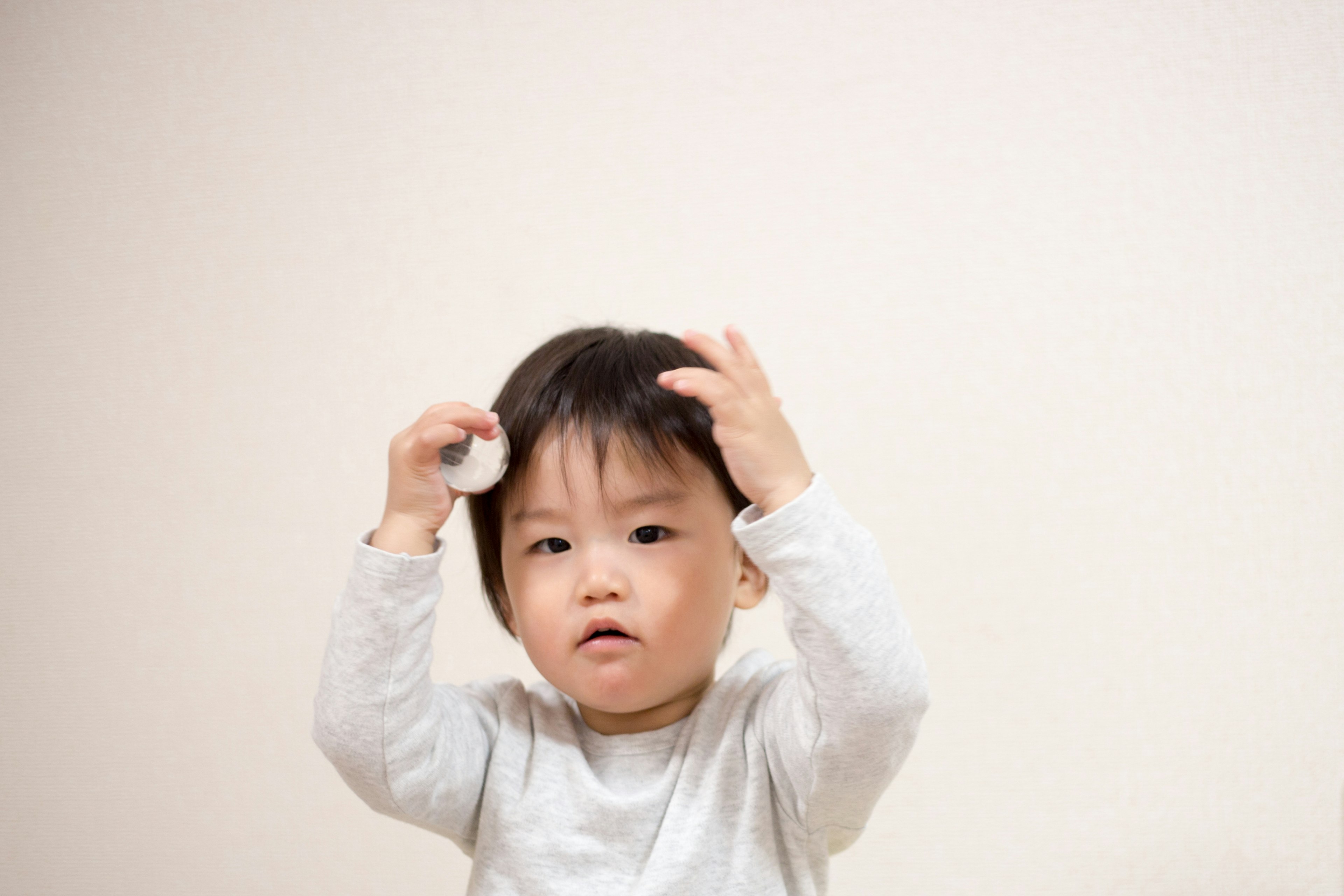 A child playing in front of a white background