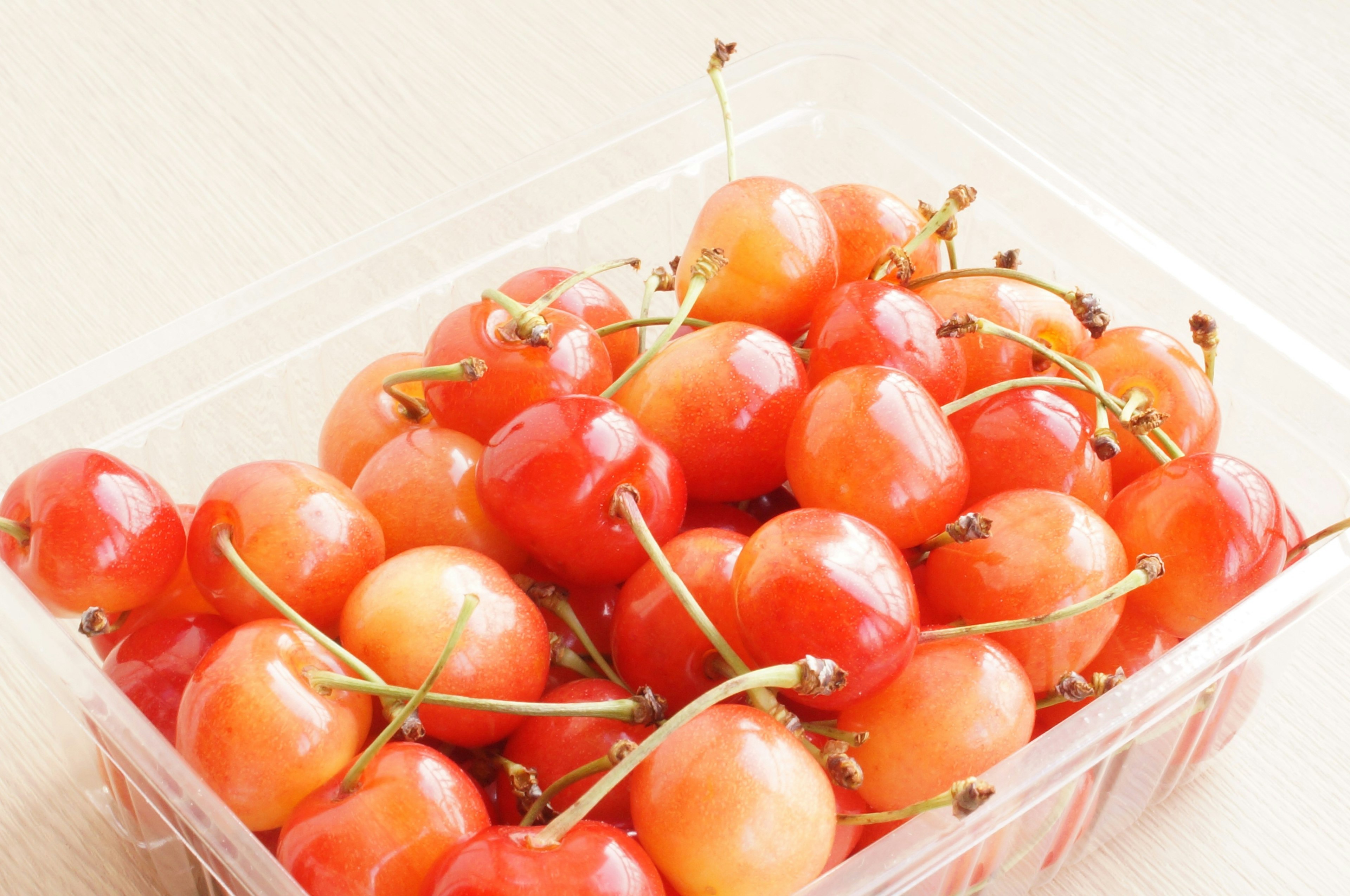 A clear container filled with bright red cherries