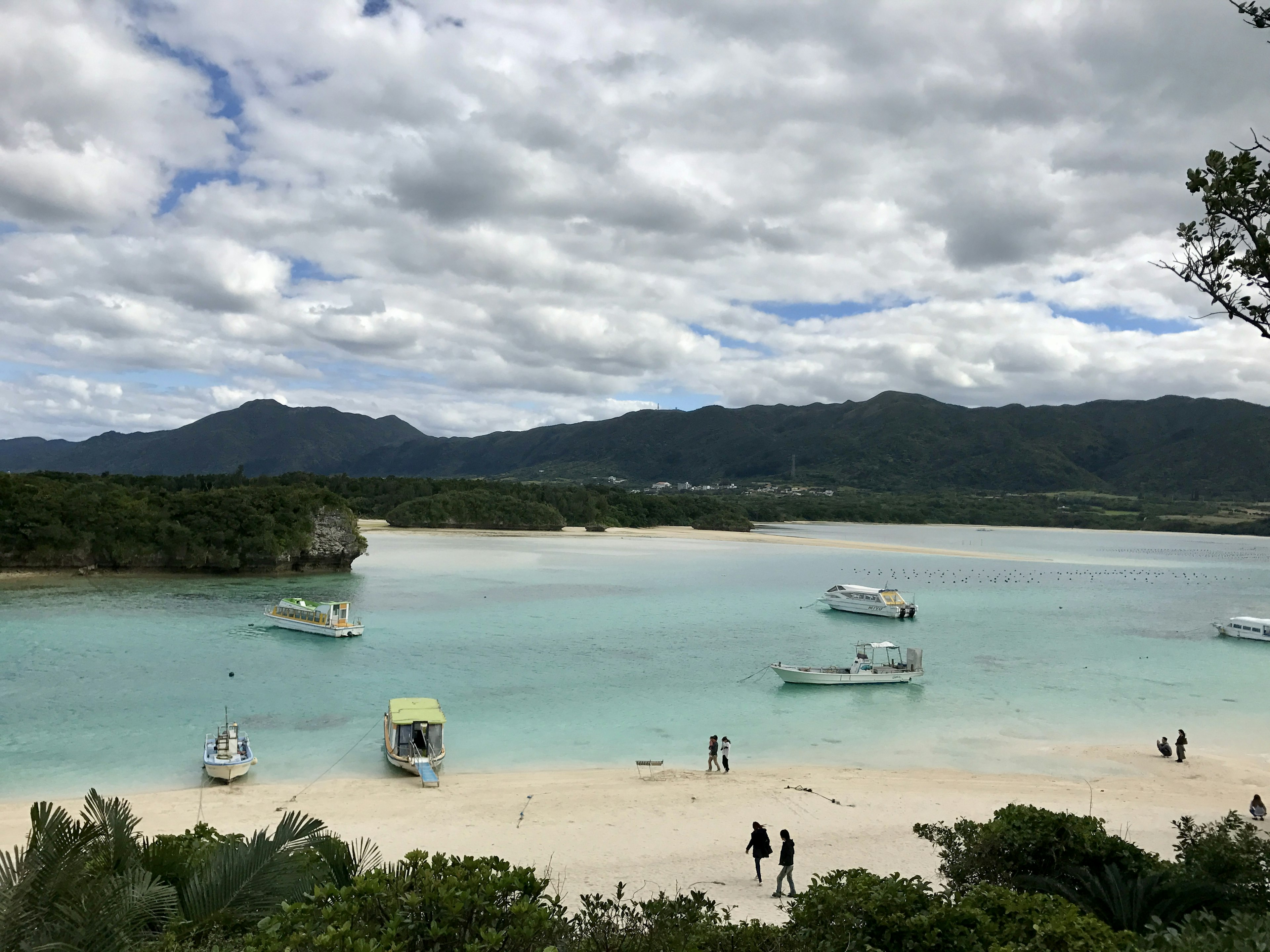 美麗的海灘景色，碧綠的水和附近停靠的船隻