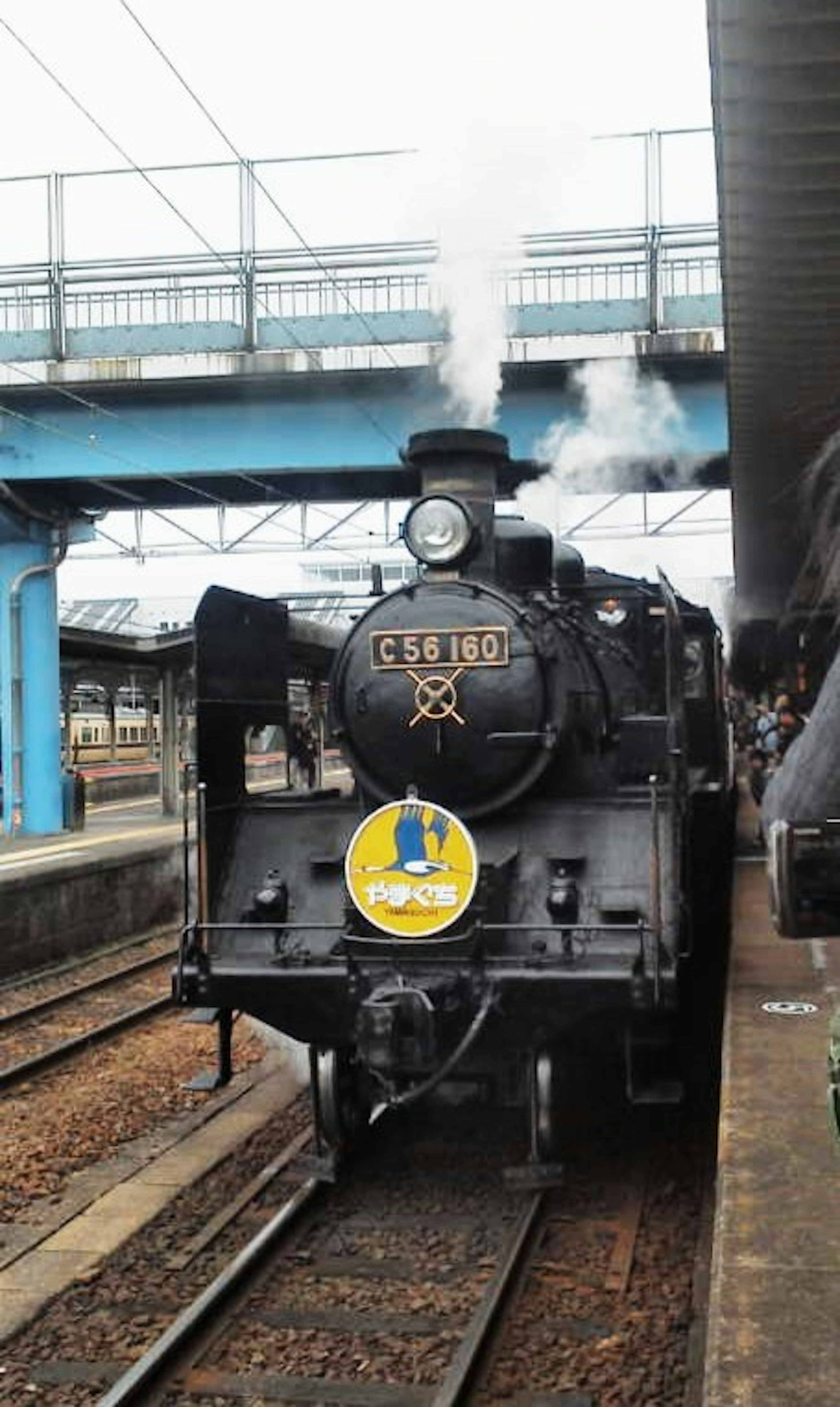 Locomotiva a vapore in stazione che emette fumi