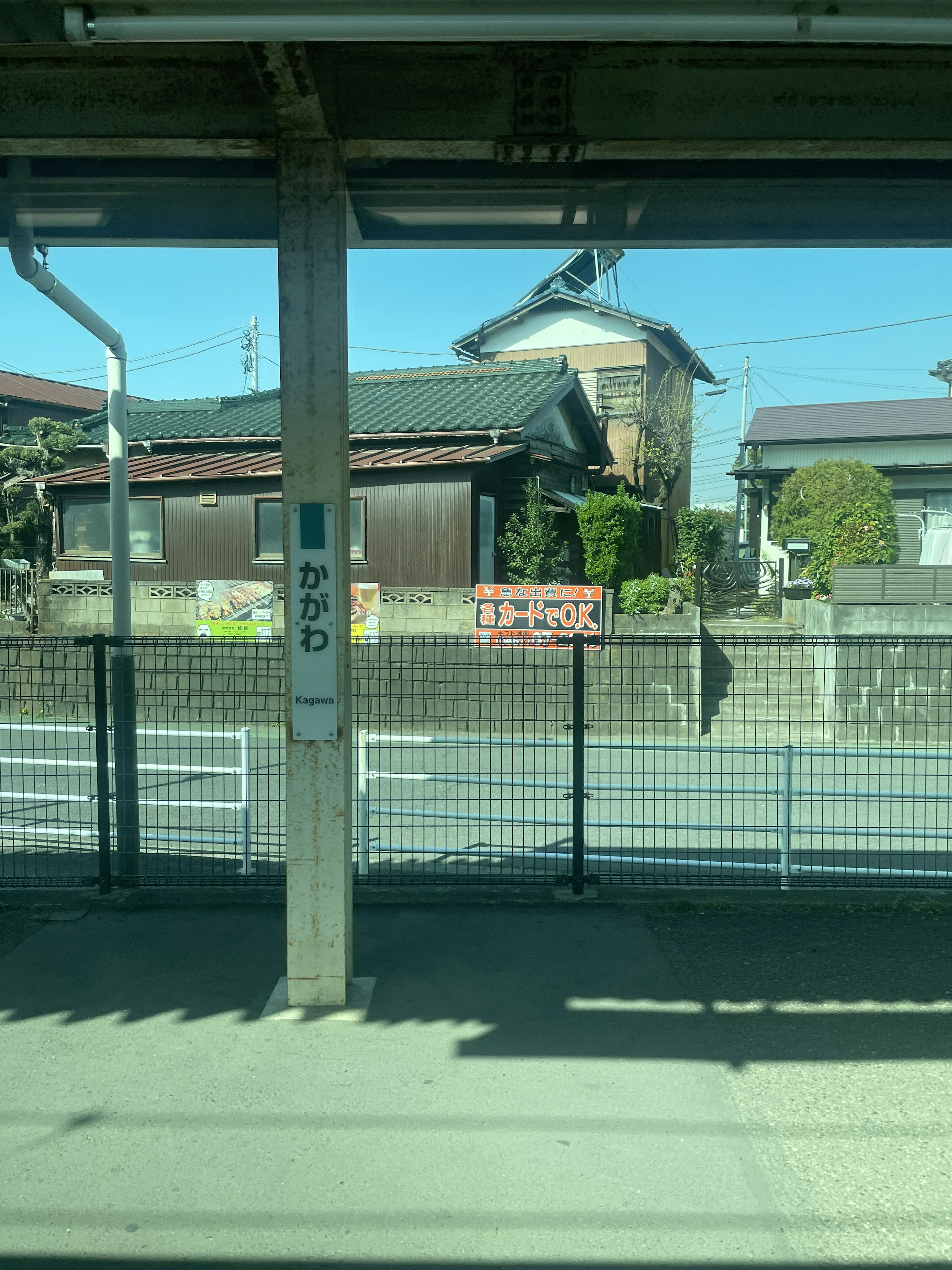 Blick auf ein japanisches Haus und einen Zaun von einem Bahngleis