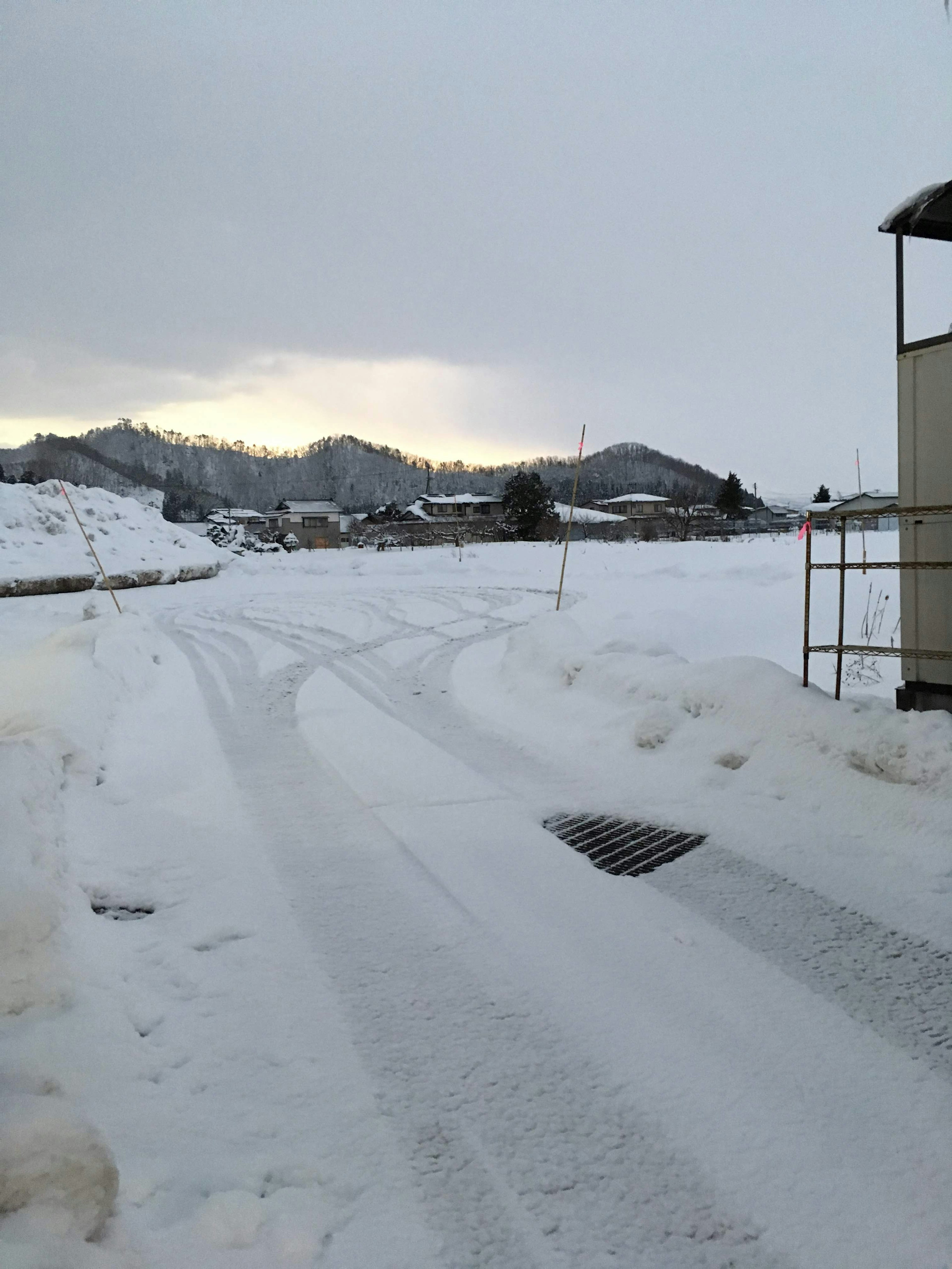 Schneebedeckte Straße mit entfernten Bergen im Hintergrund