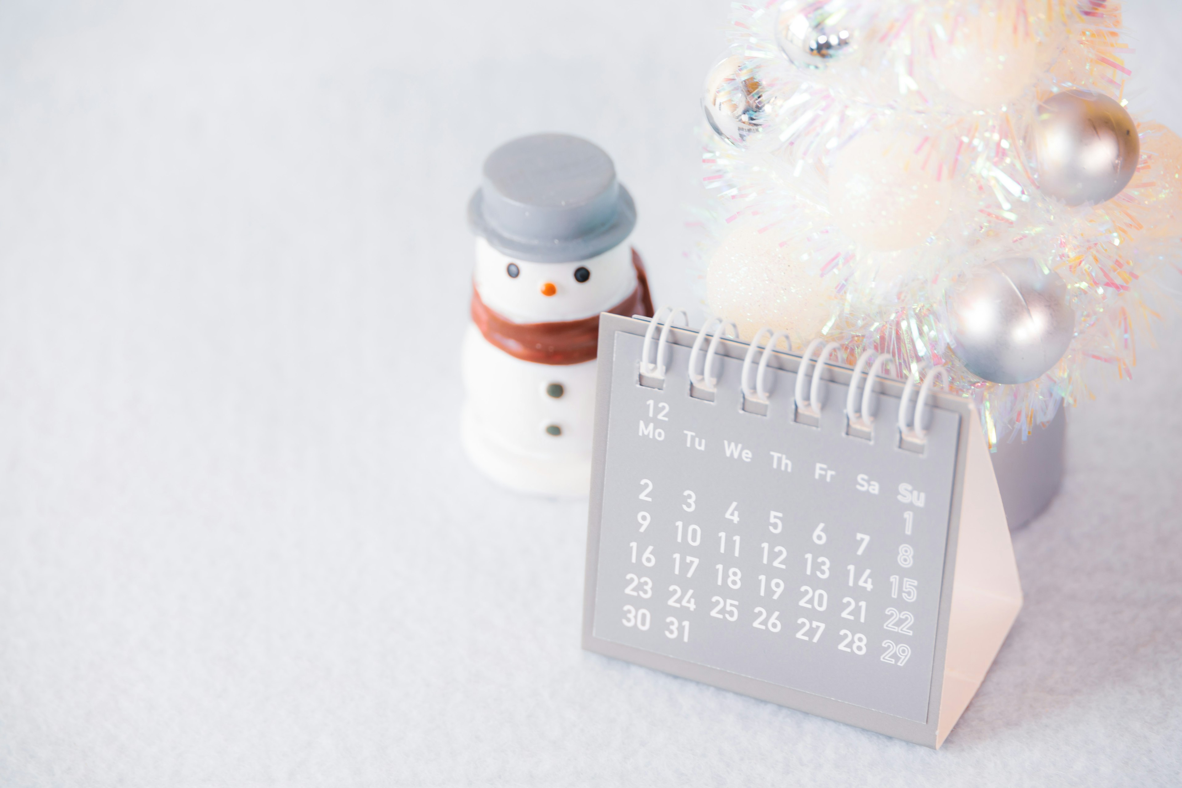 Calendario de temática invernal con un muñeco de nieve y un árbol de Navidad