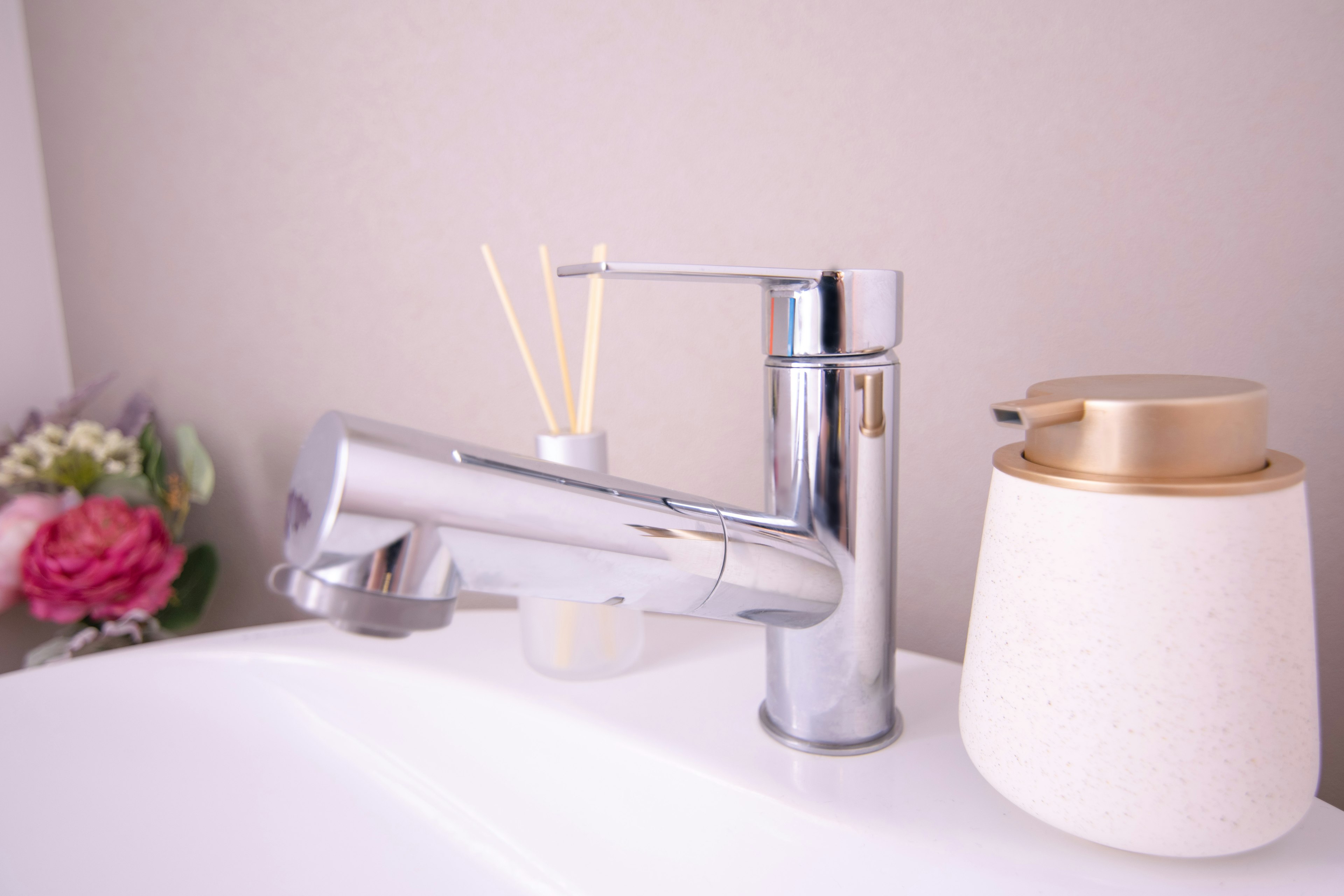 A modern bathroom sink featuring a sleek chrome faucet and a decorative diffuser