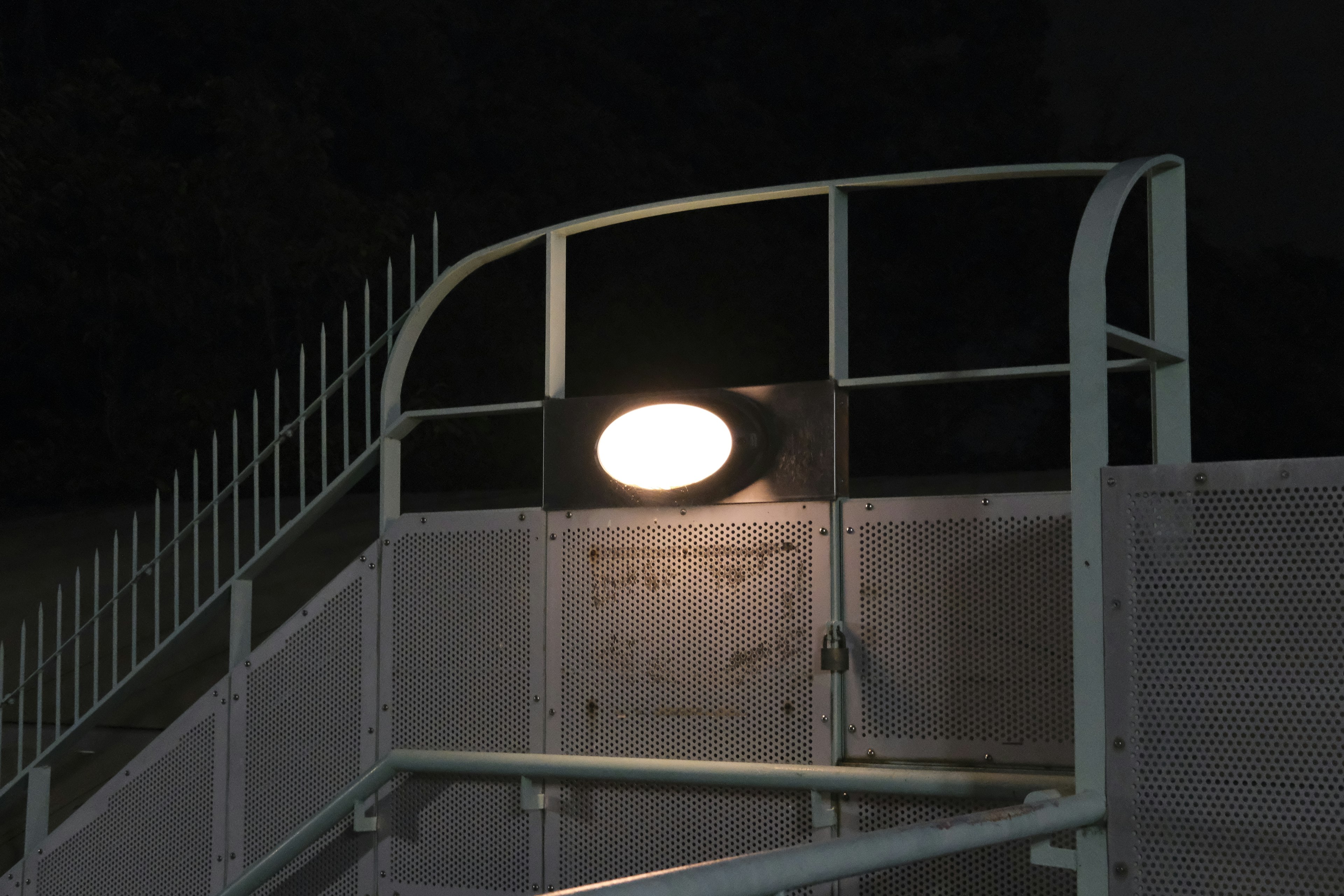 Luz redonda montada en la barandilla de una escalera por la noche