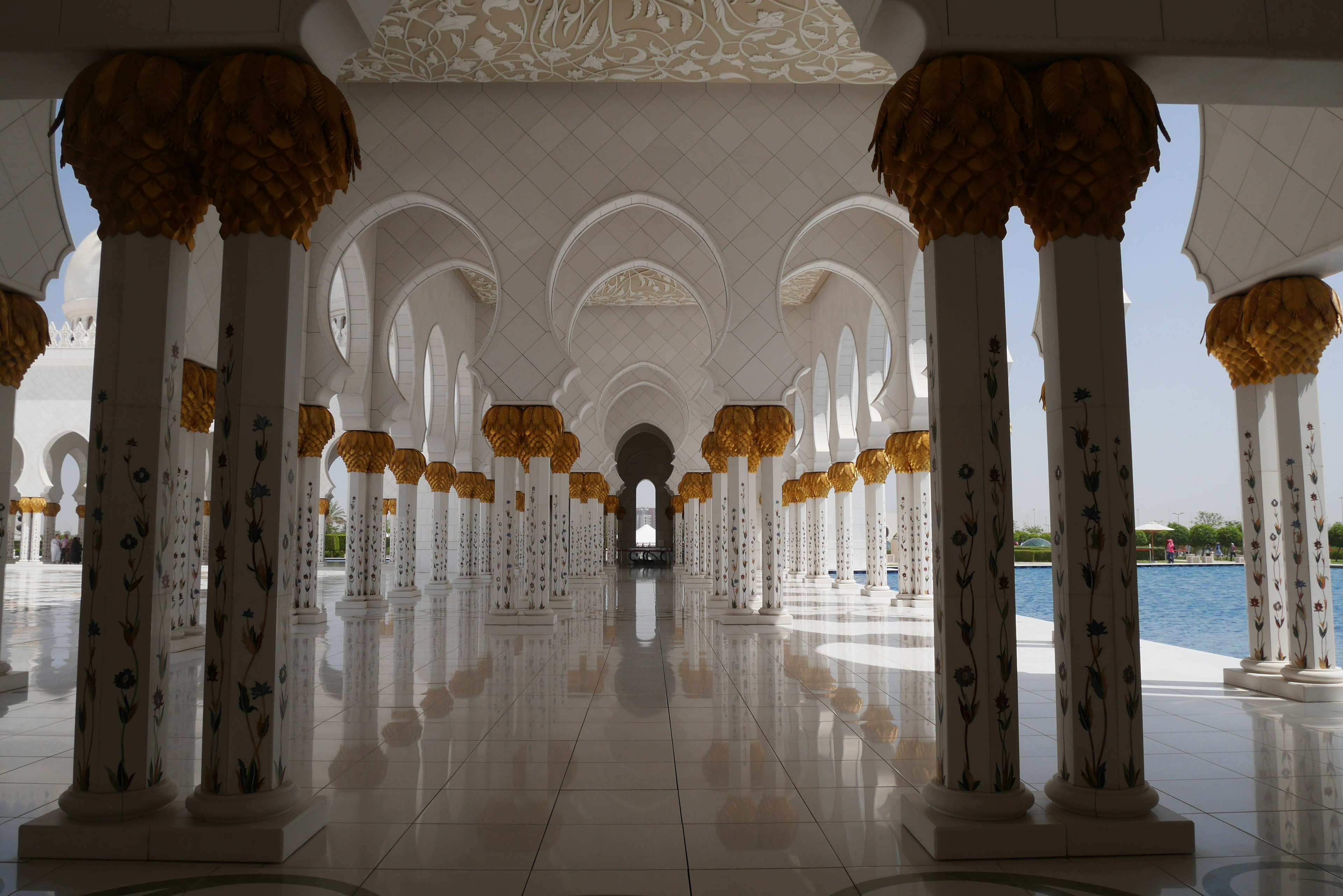 Interior of a beautiful building with white marble columns and golden decorations in an archway