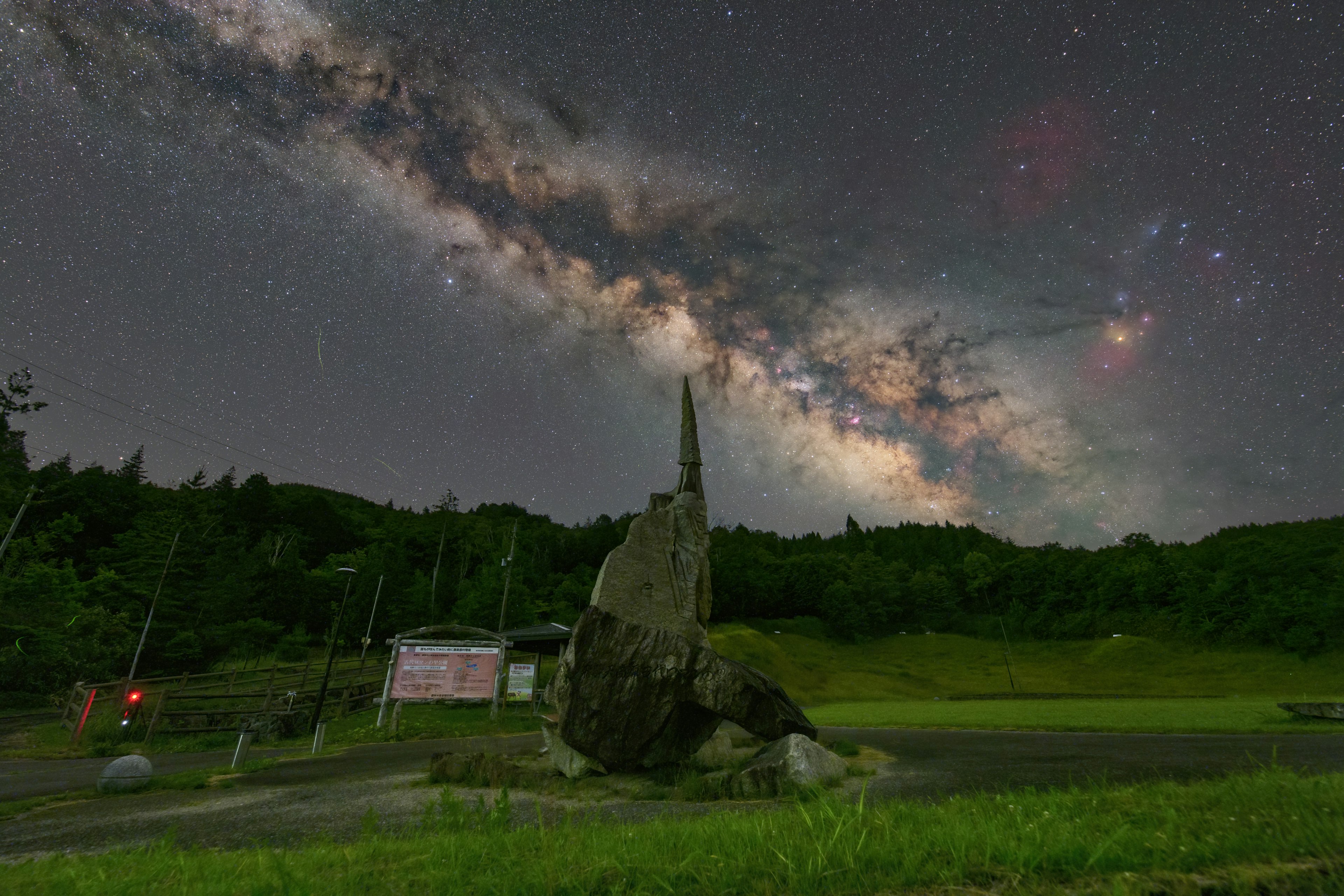 星空の下にある大きな岩と銀河の壮大な景色