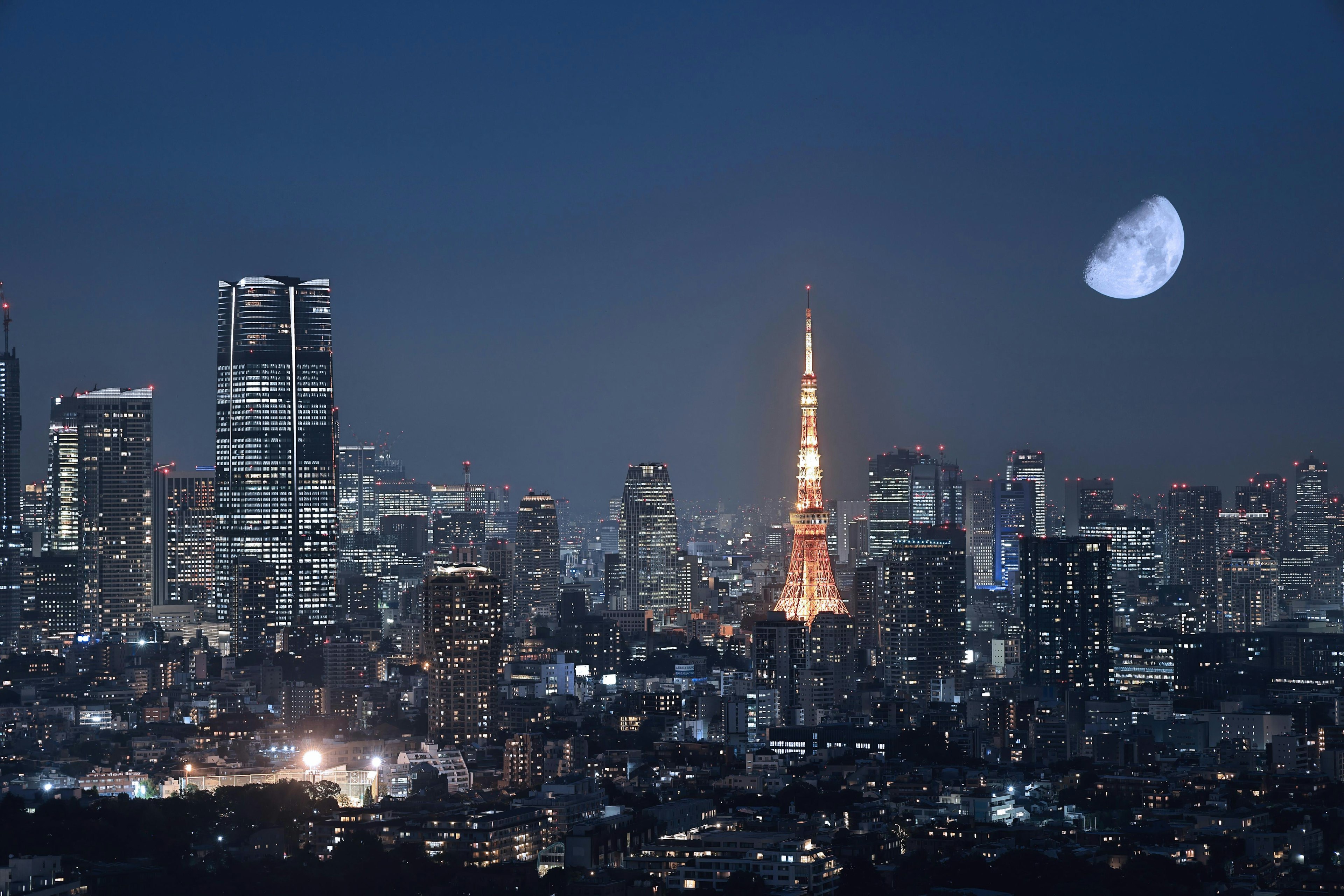 夜間東京塔和摩天大樓的景觀，背景為黑暗的天空