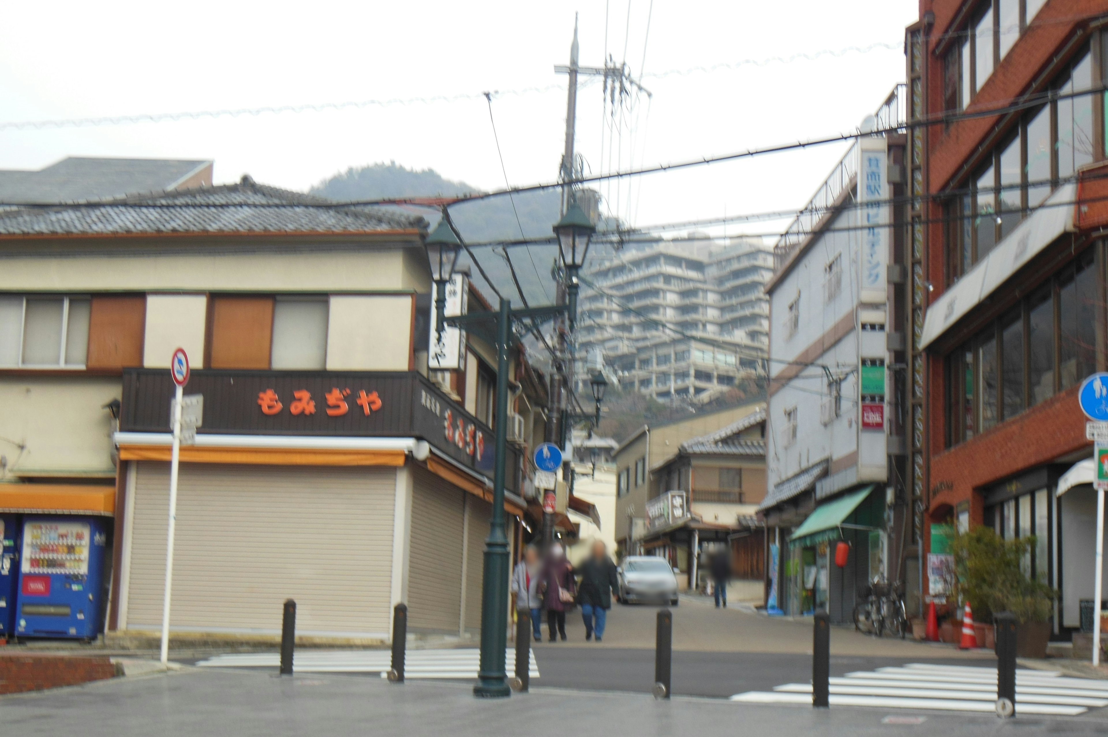 Street scene with people walking and old buildings lining the road