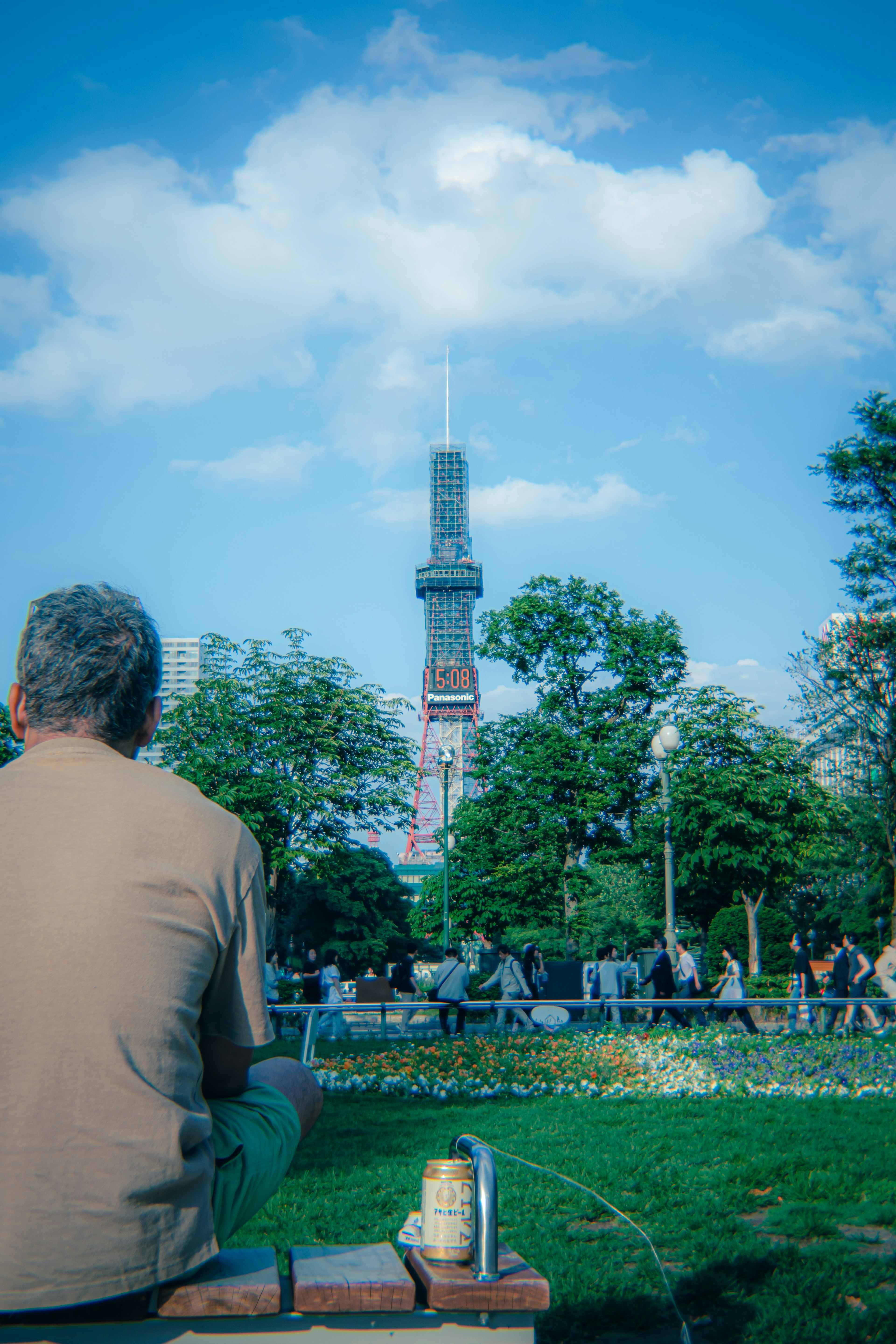 公園で後ろを向く男性と東京スカイツリーの風景