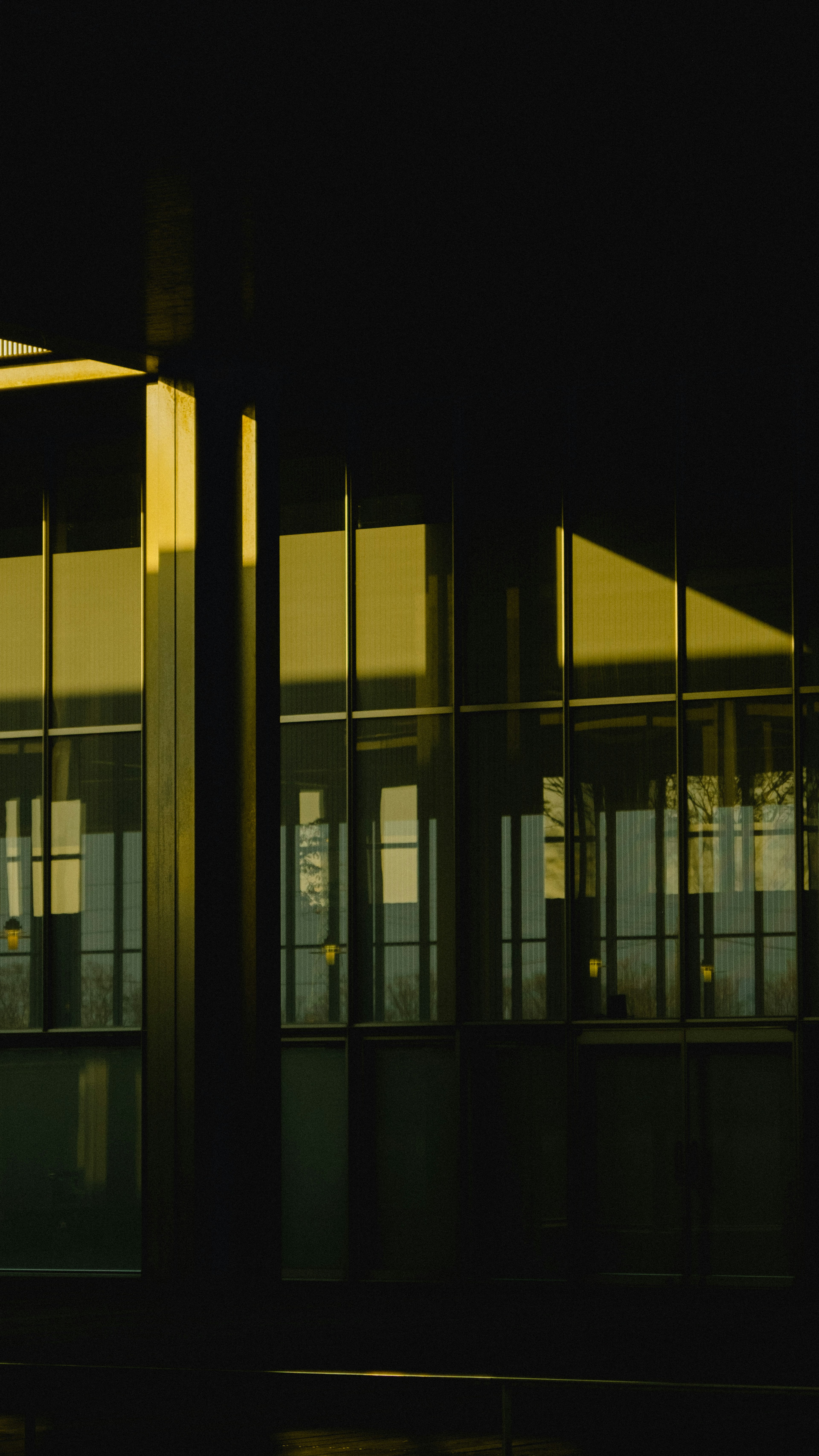 Reflection of yellow light on glass windows with a dark background