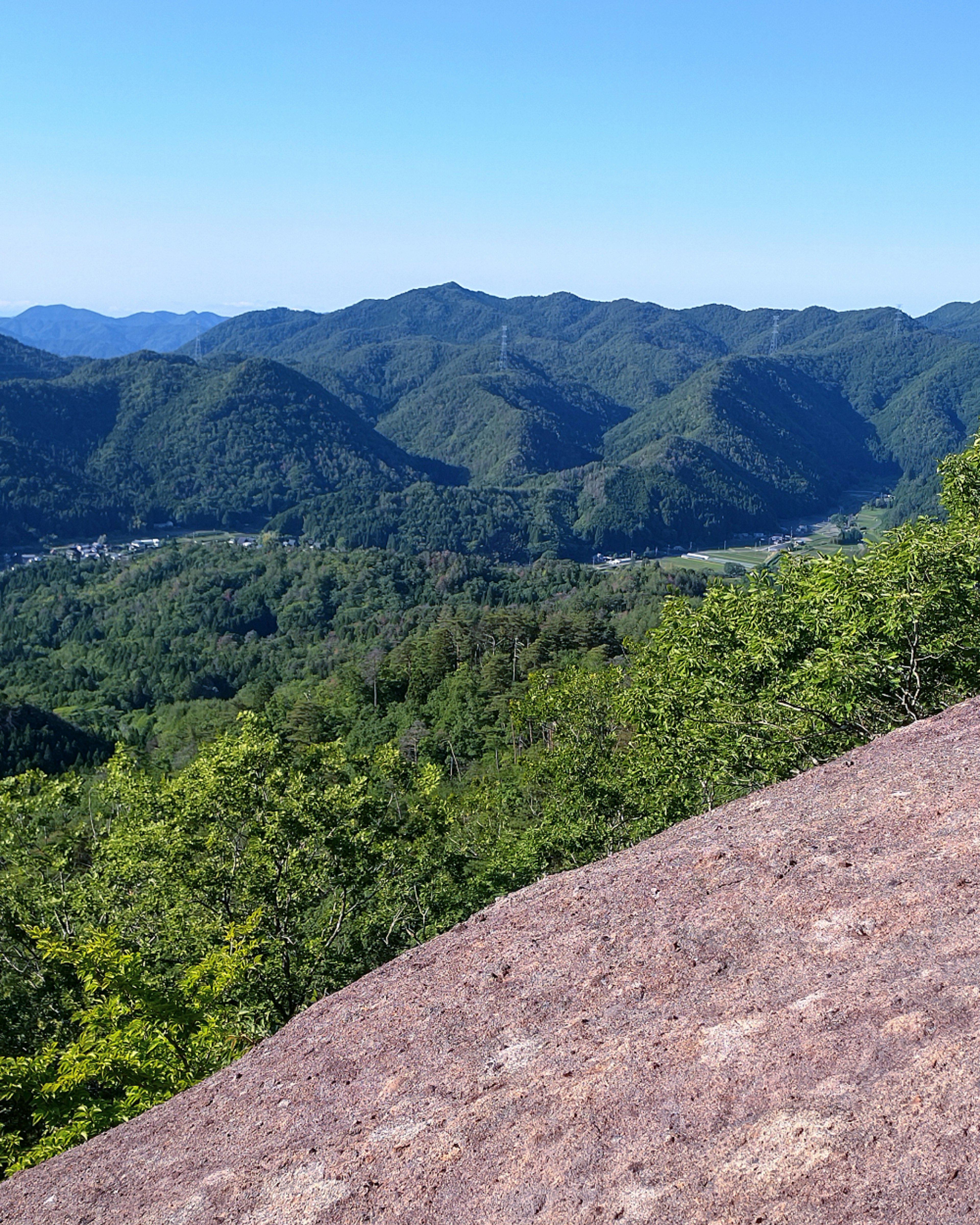 緑豊かな山々と青空が広がる風景の画像