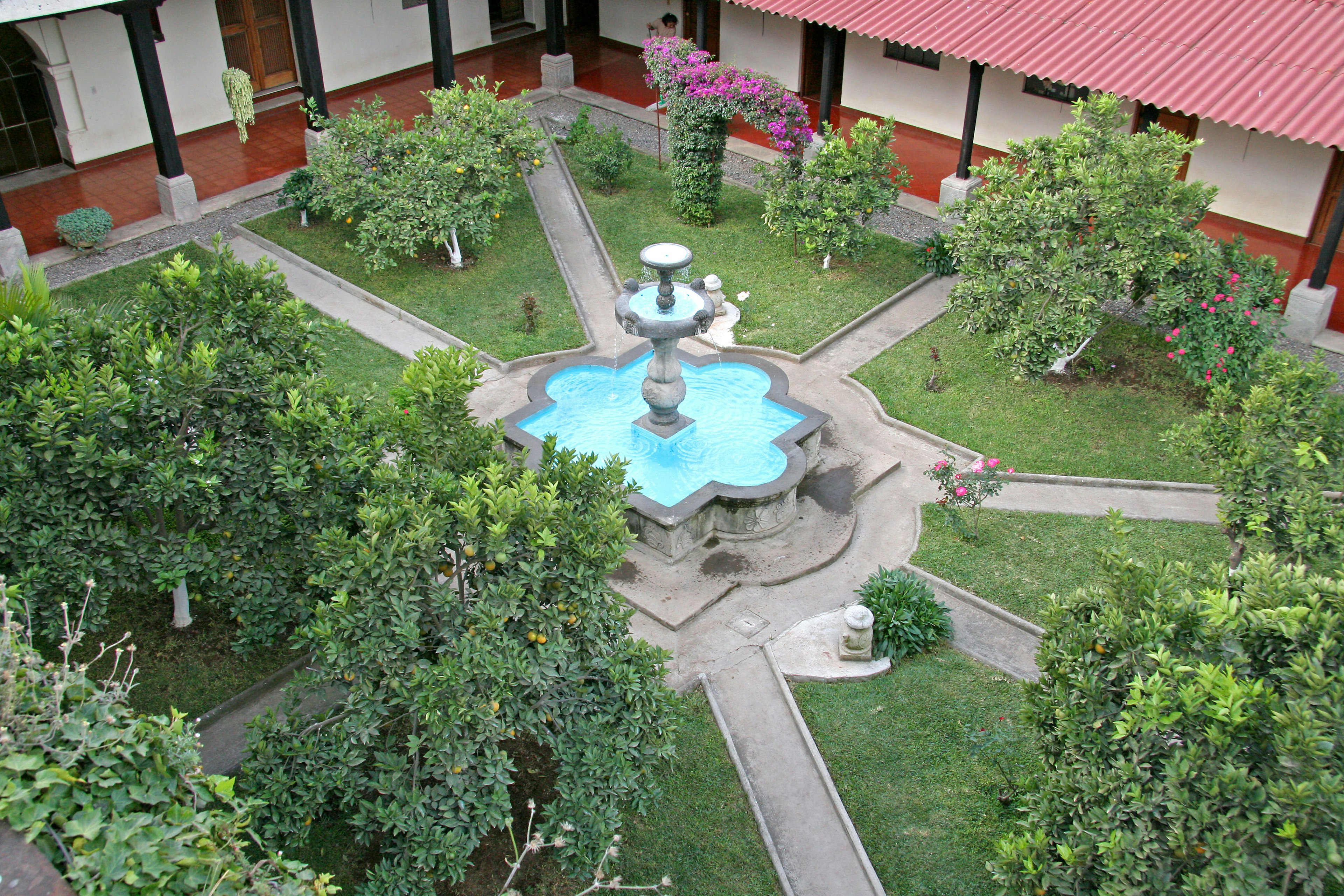 Aerial view of a courtyard featuring a fountain surrounded by trees