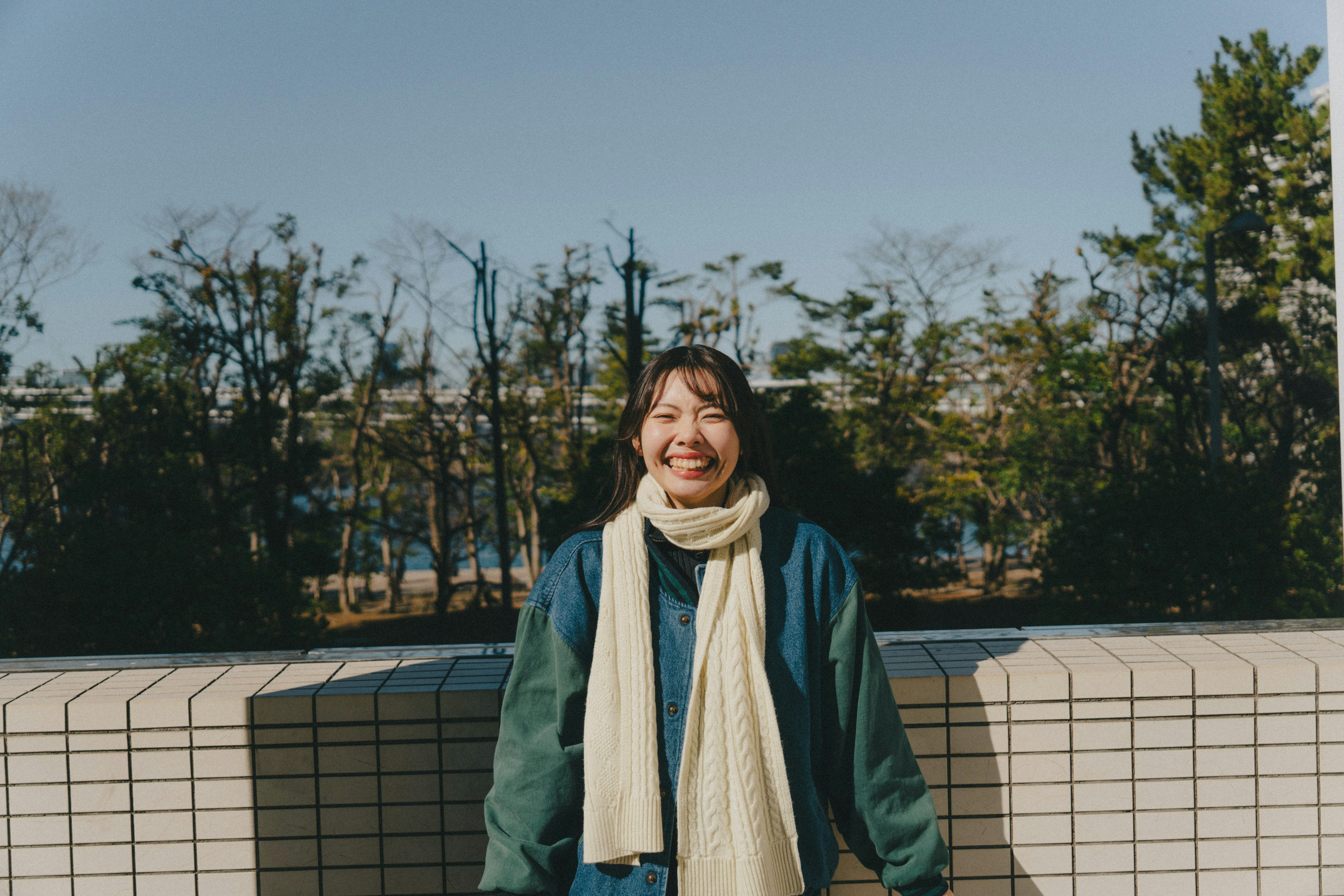 公園で笑顔の女性が白いスカーフを着けている