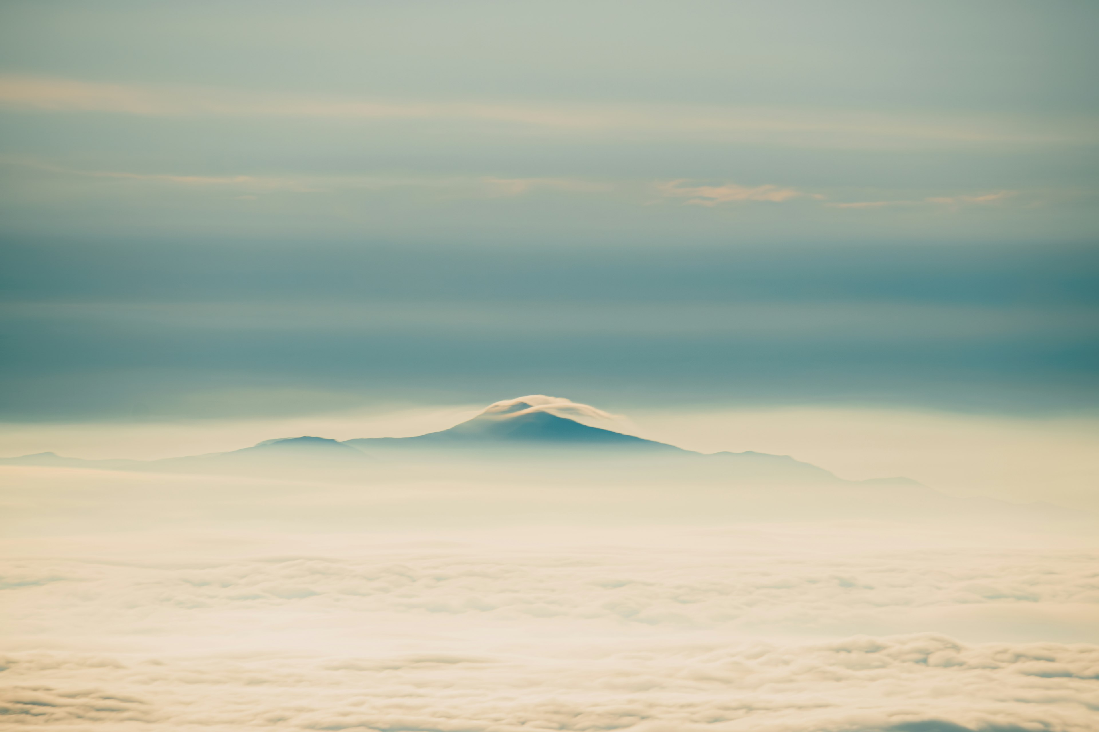 Sommet de montagne visible à travers une mer de brouillard