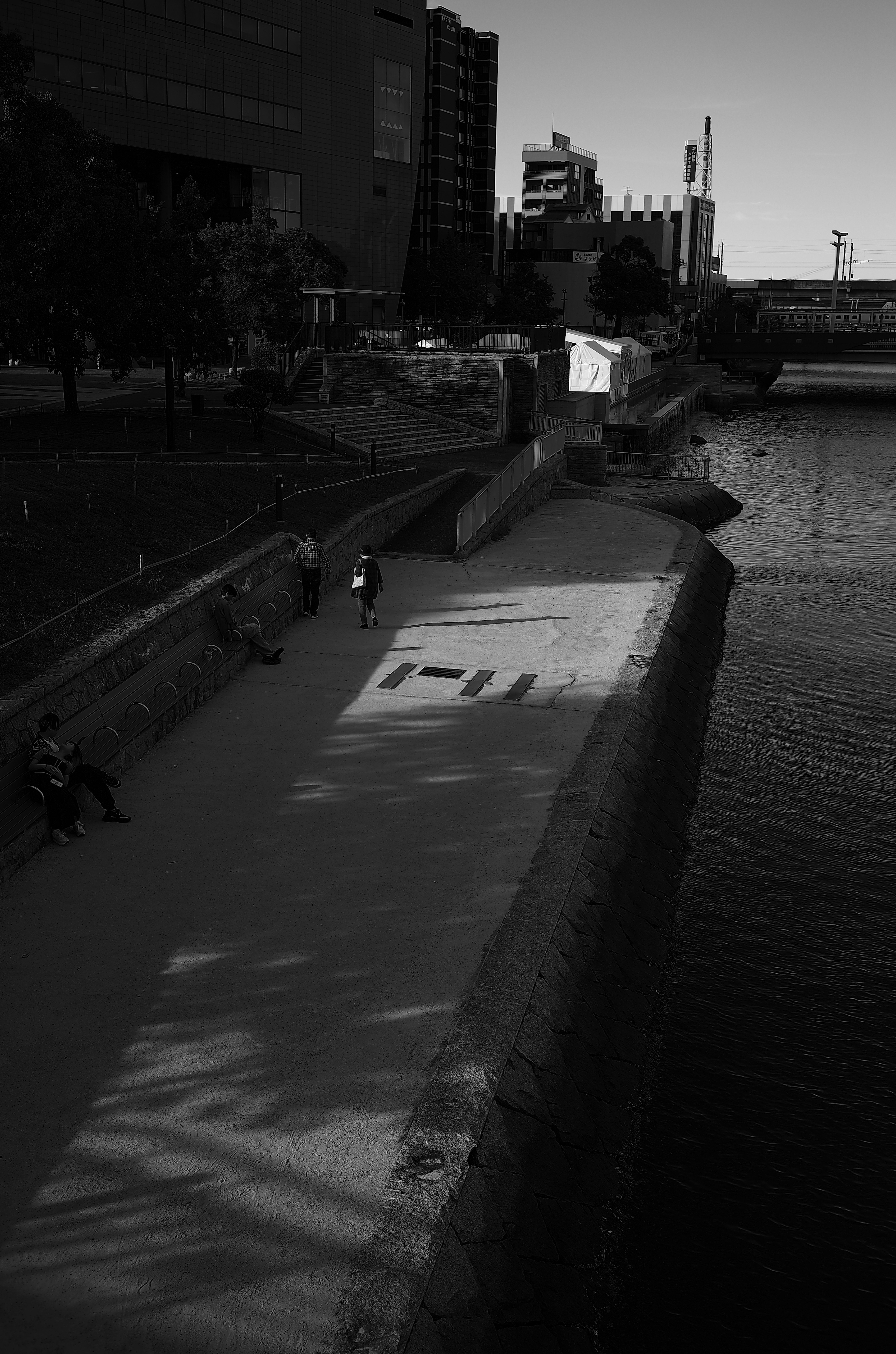 Promenade au bord de la rivière en noir et blanc avec des ombres