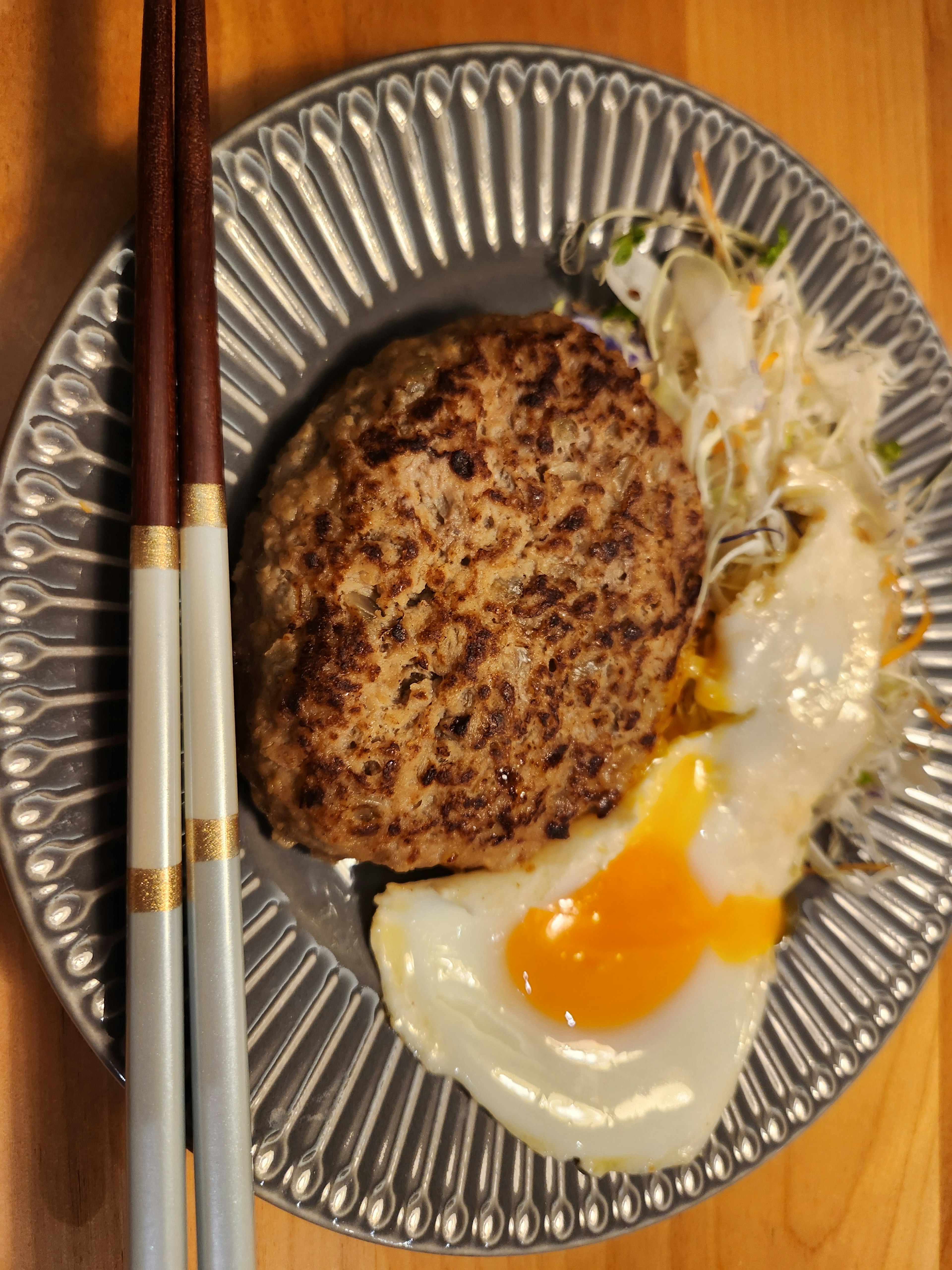 Grilled hamburger steak with fried egg on a plate