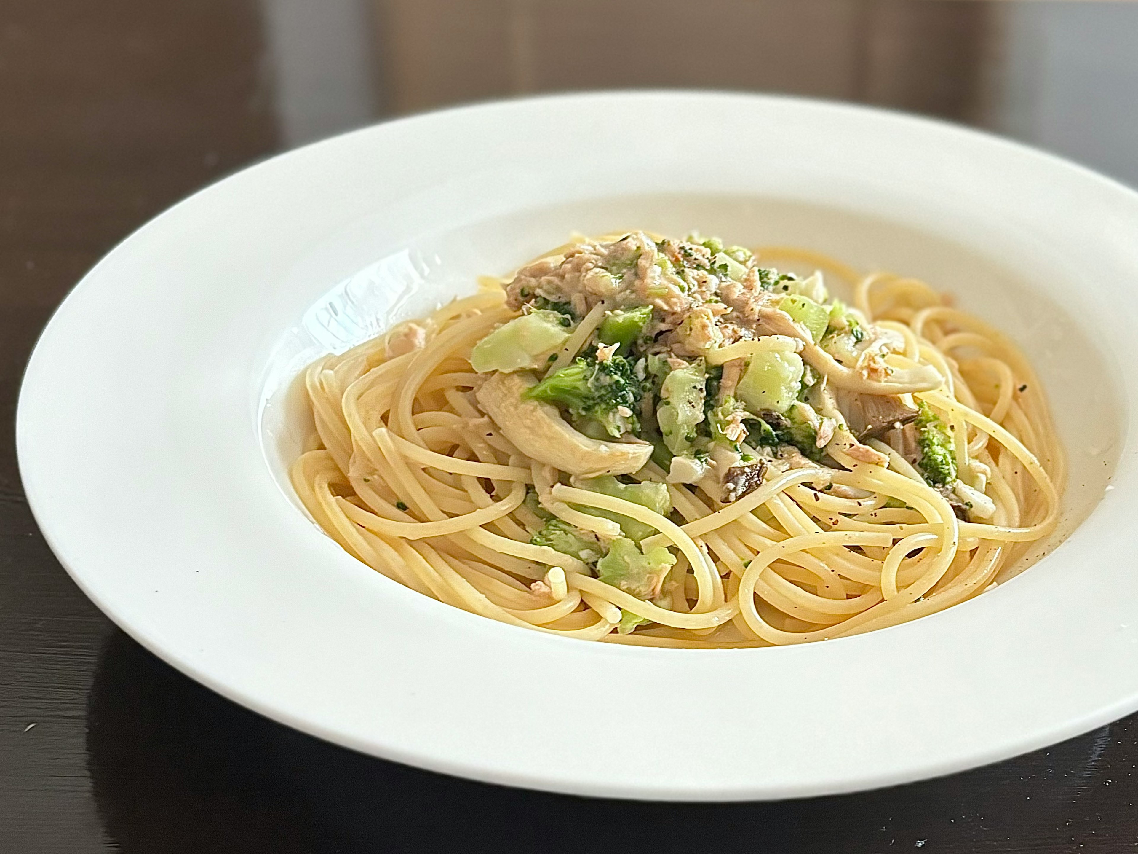 クリームソースのパスタと野菜が盛り付けられた白い皿