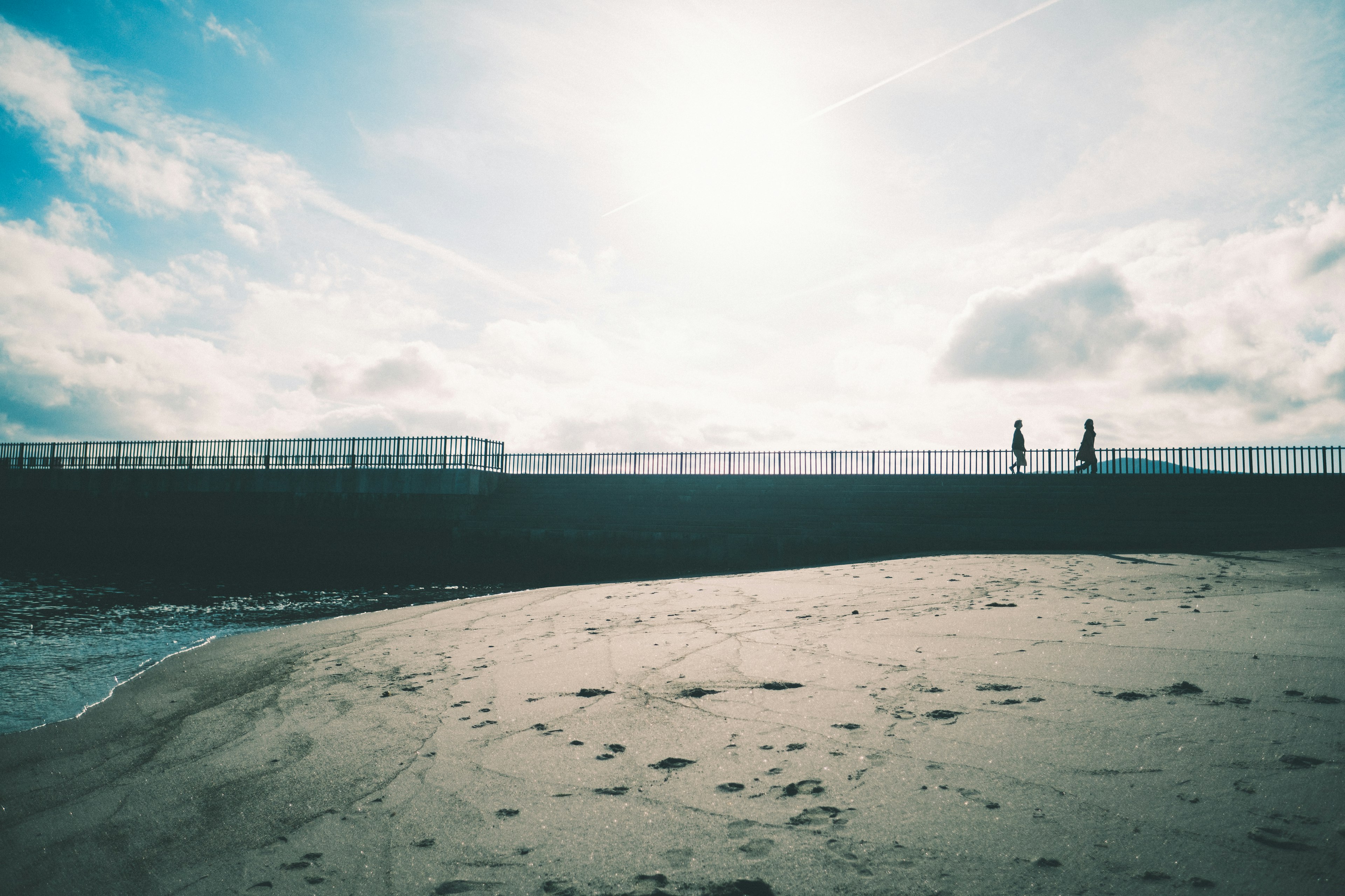 Menschen, die an einem Strand mit blauem Himmel spazieren