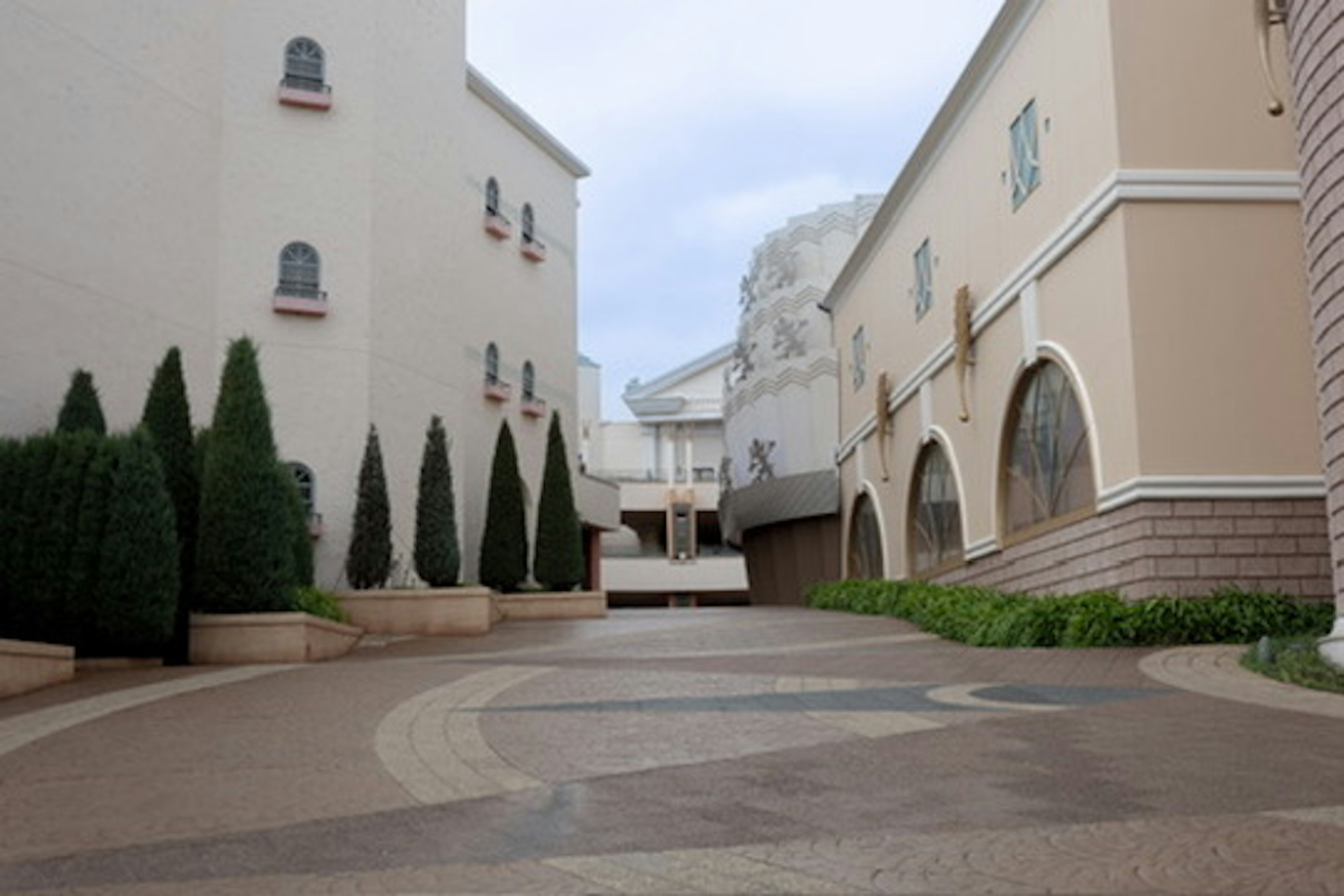 Quiet street with white buildings and green shrubs