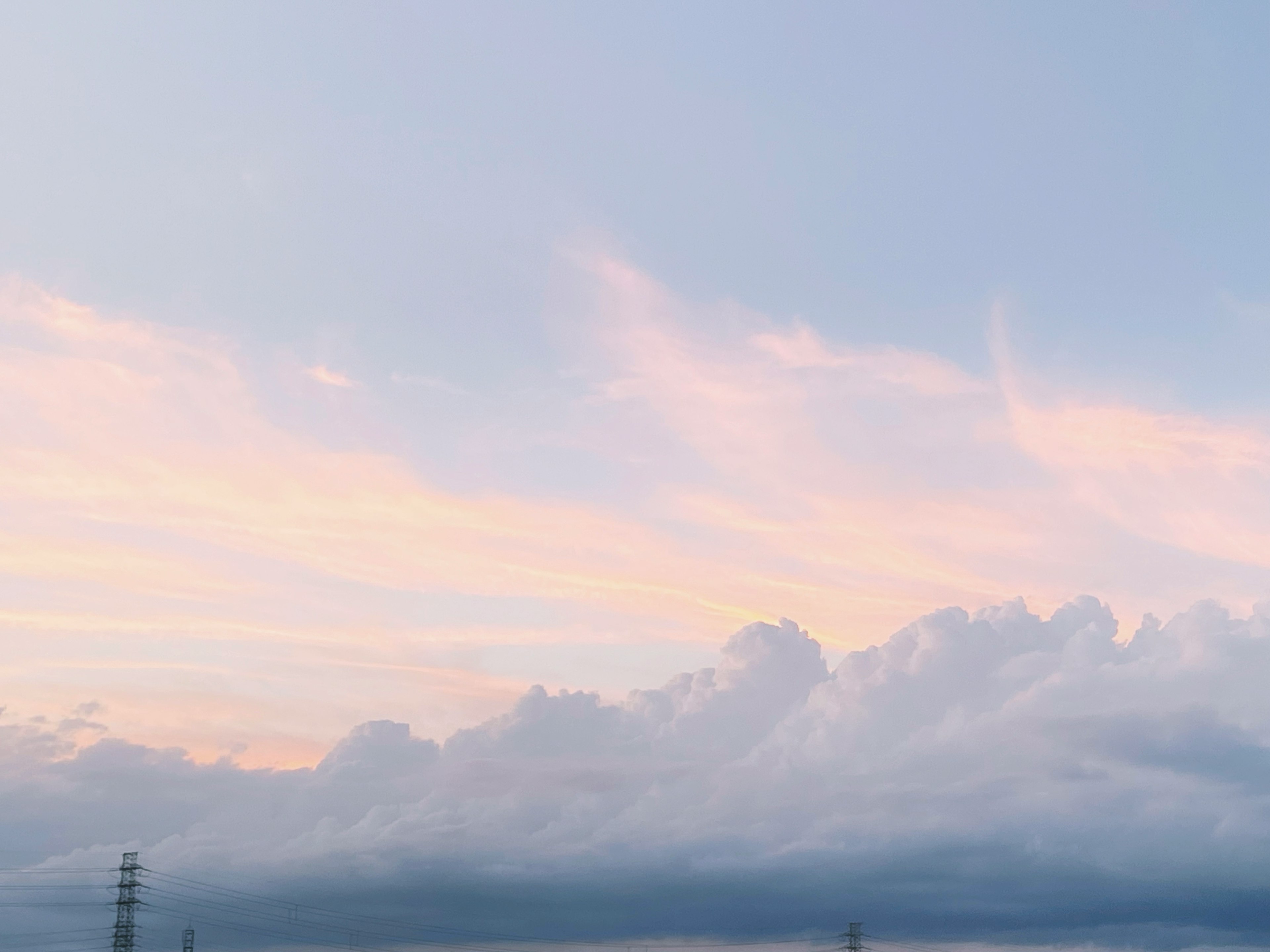 夕焼けの空に広がる淡いピンクと青の雲