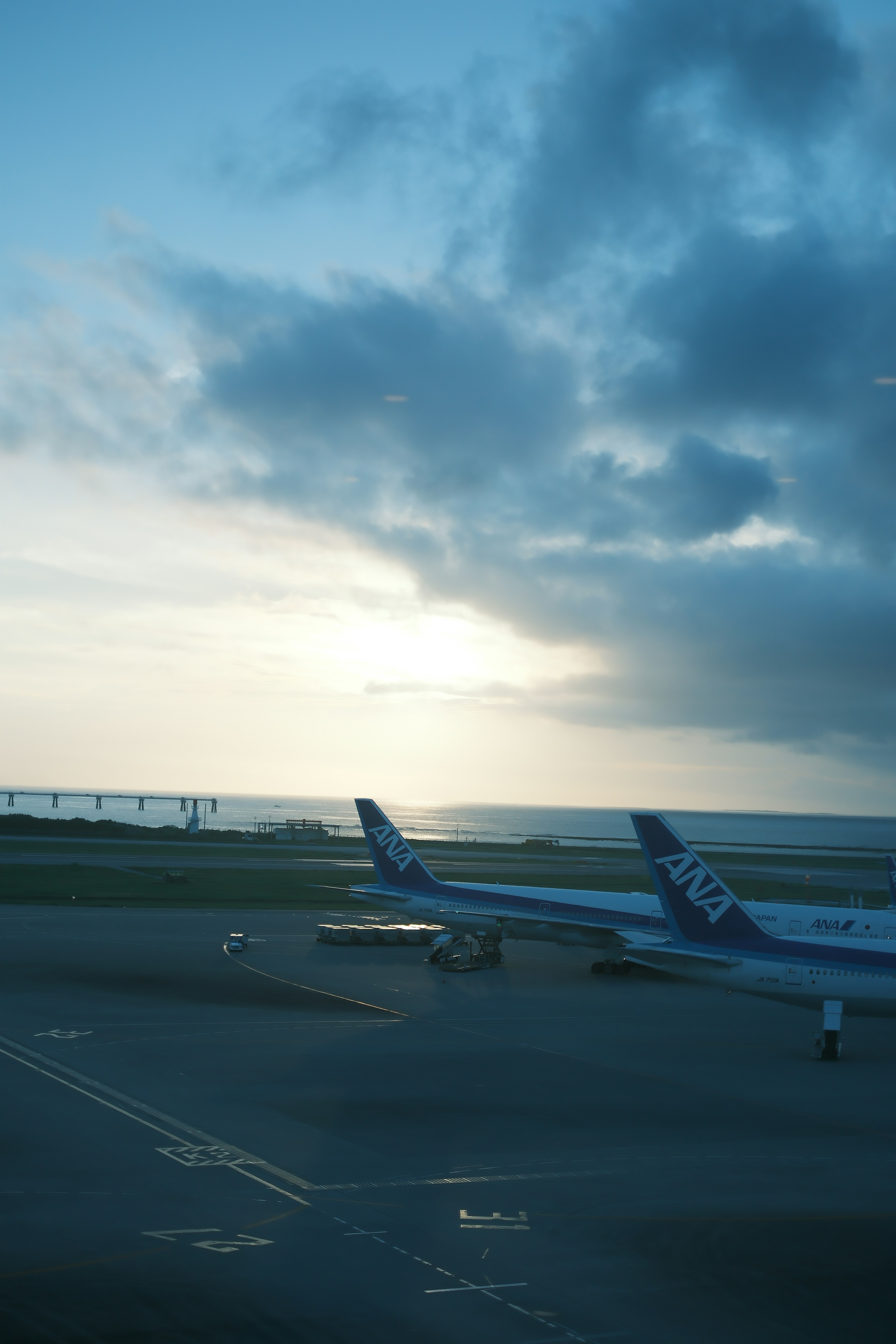 空港の滑走路に停まる飛行機と海の景色