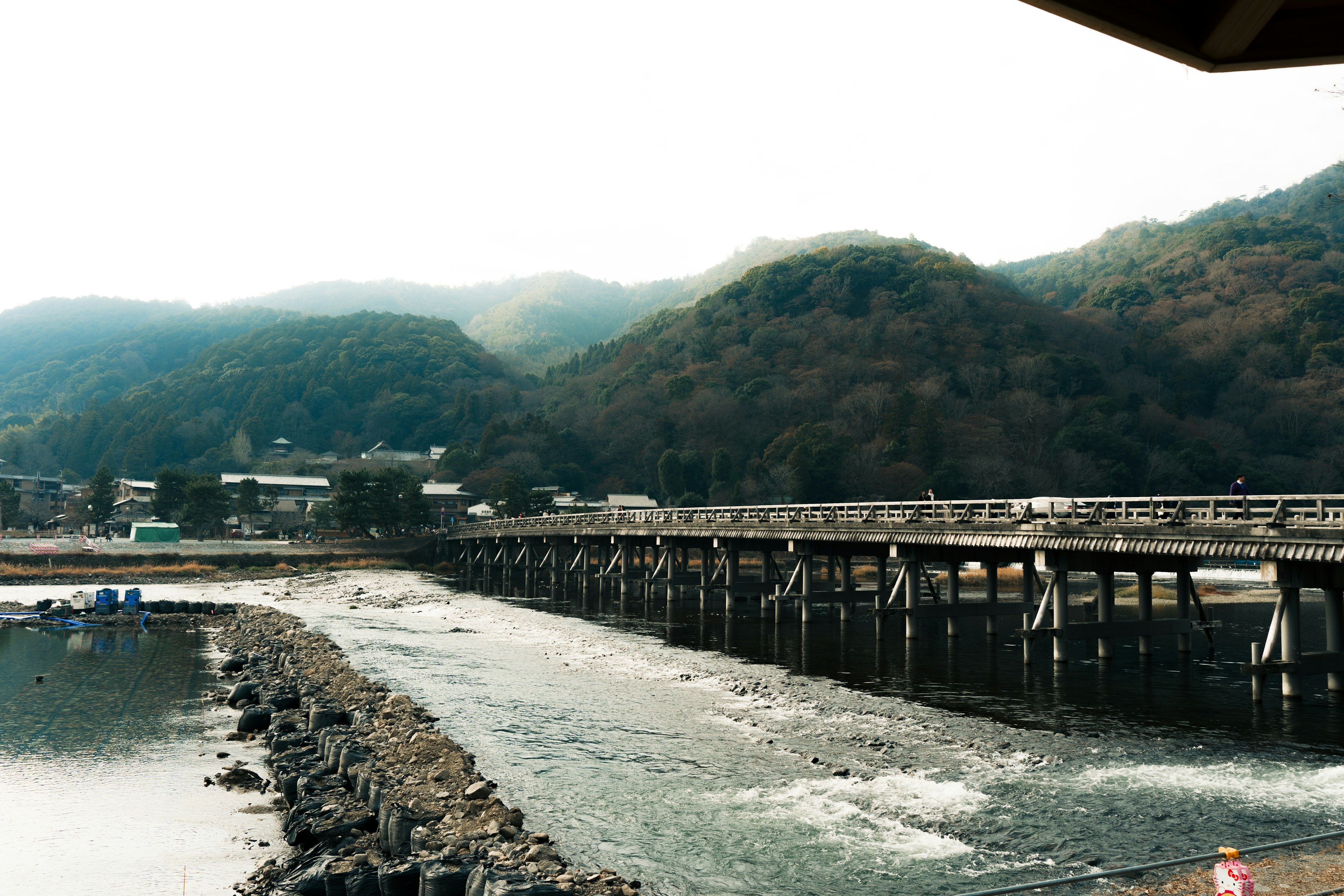 Scenic wooden bridge over a river with mountains in the background