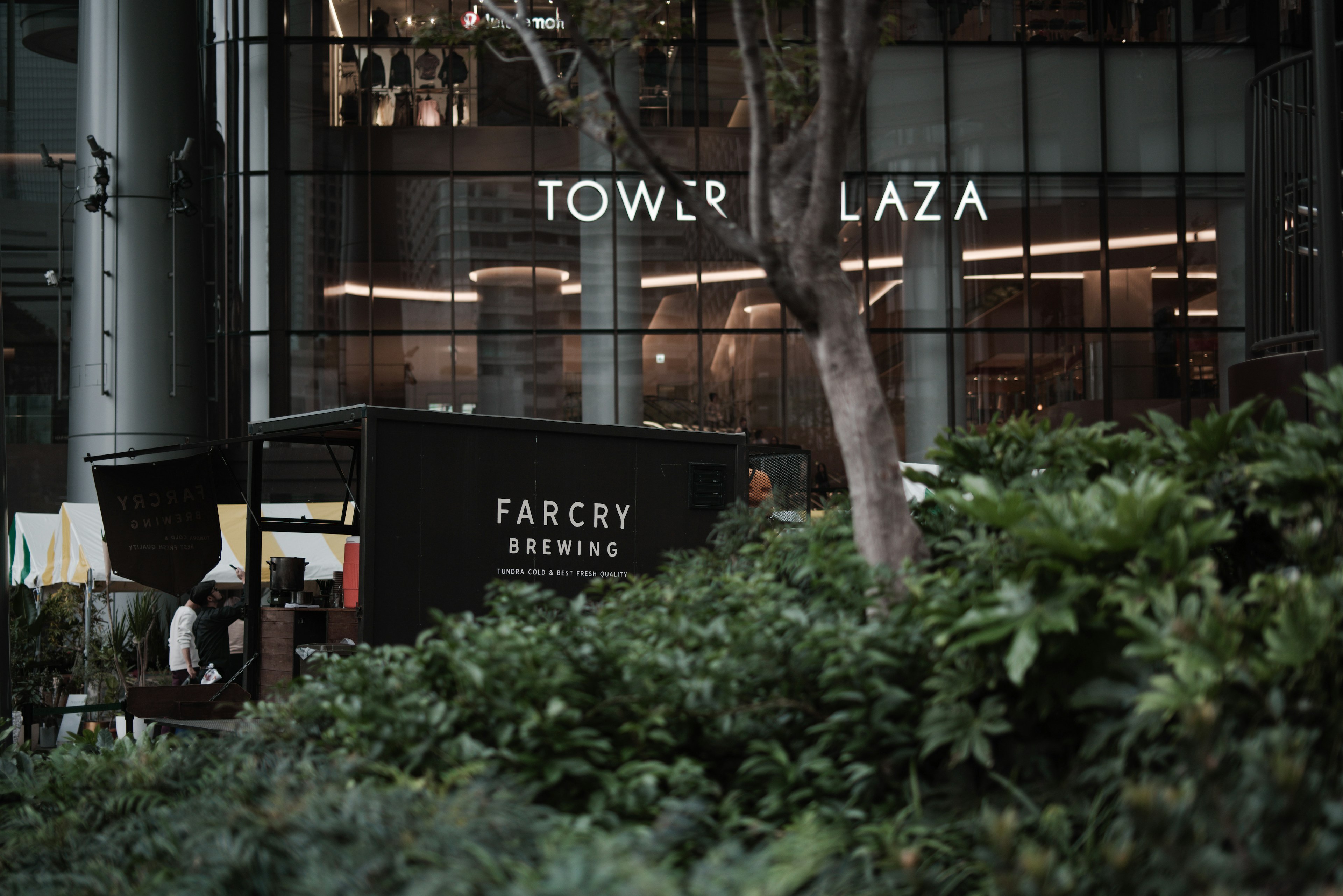 Städtische Szene mit dem Tower Plaza-Schild und üppigem Grün