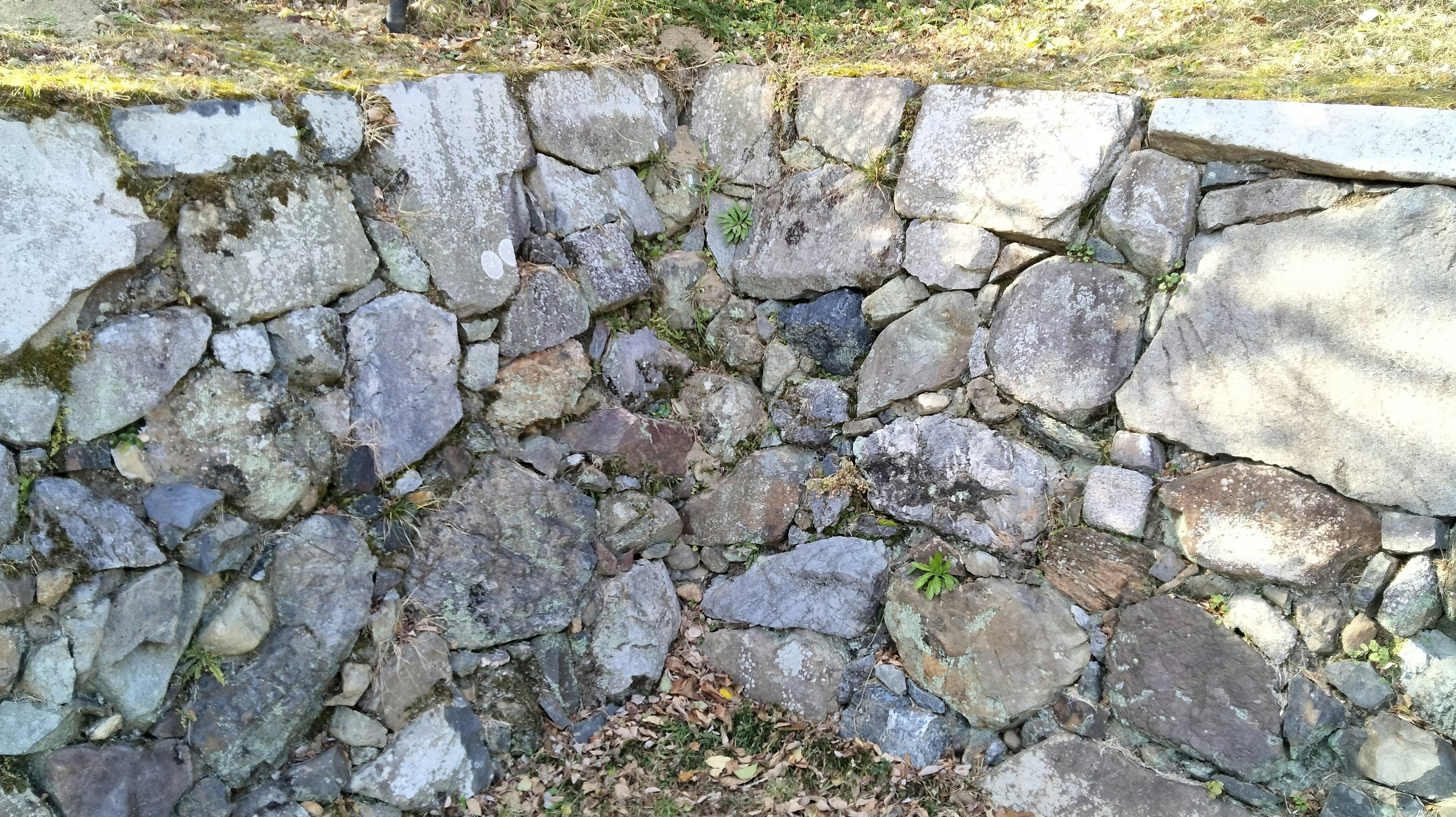 Sección de una pared de piedra con piedras de varios tamaños