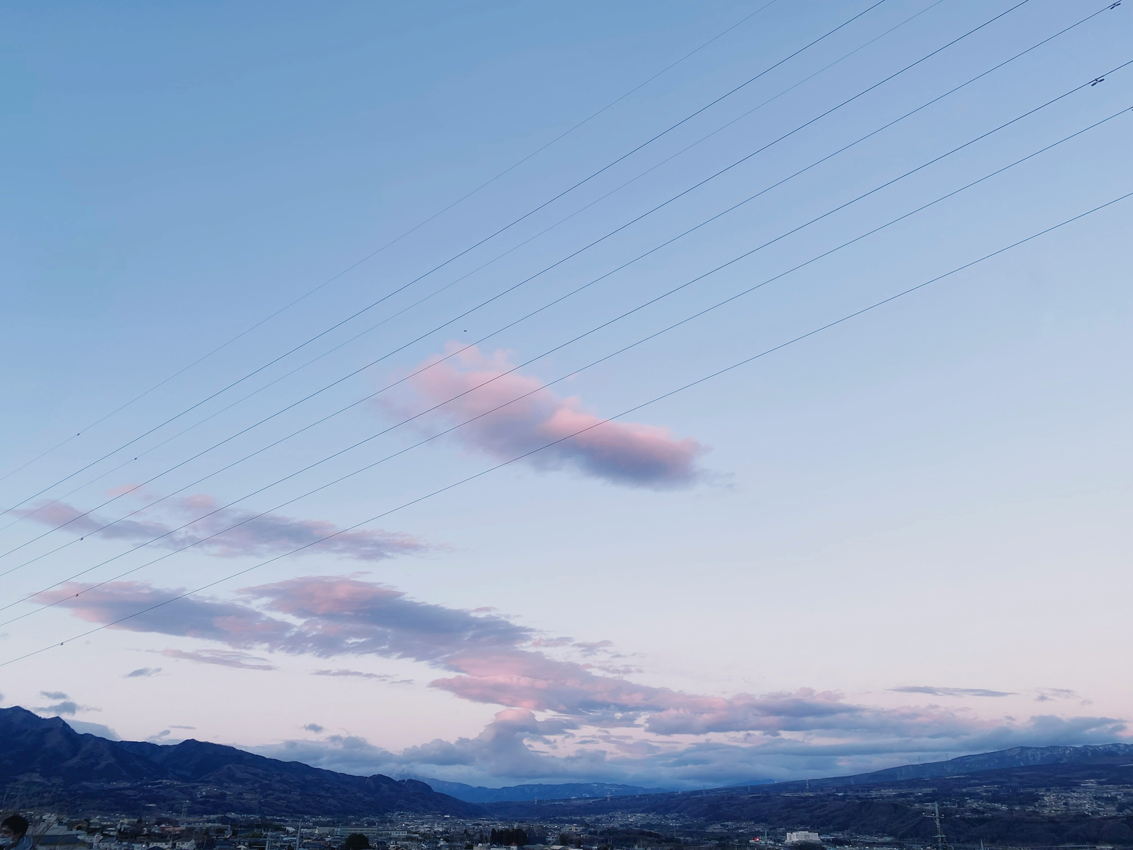 Una vista escénica de un cielo azul con nubes ligeras y montañas