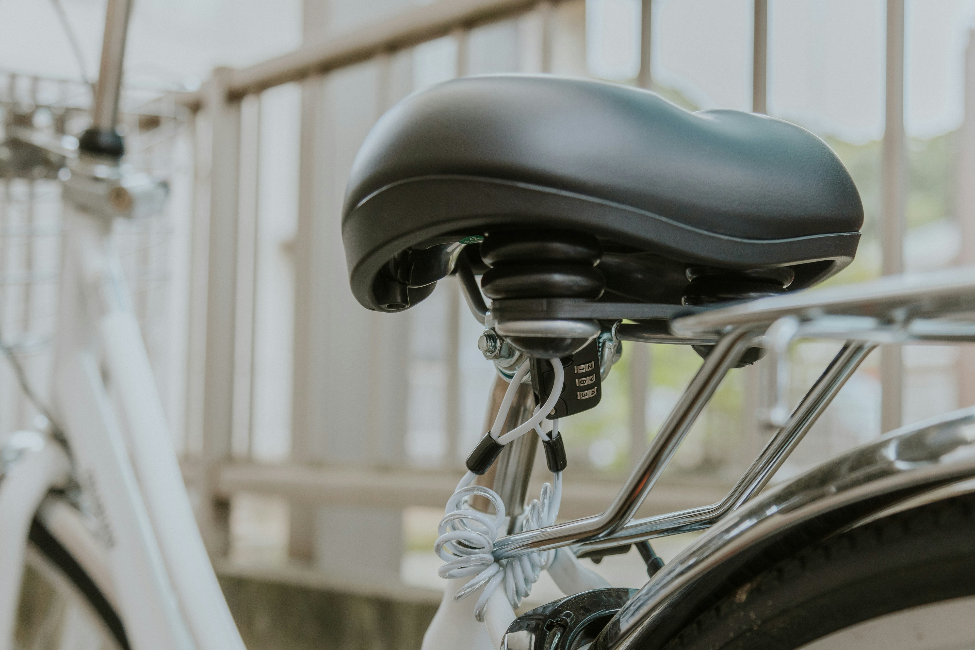 Close-up of a bicycle's black saddle and metal frame