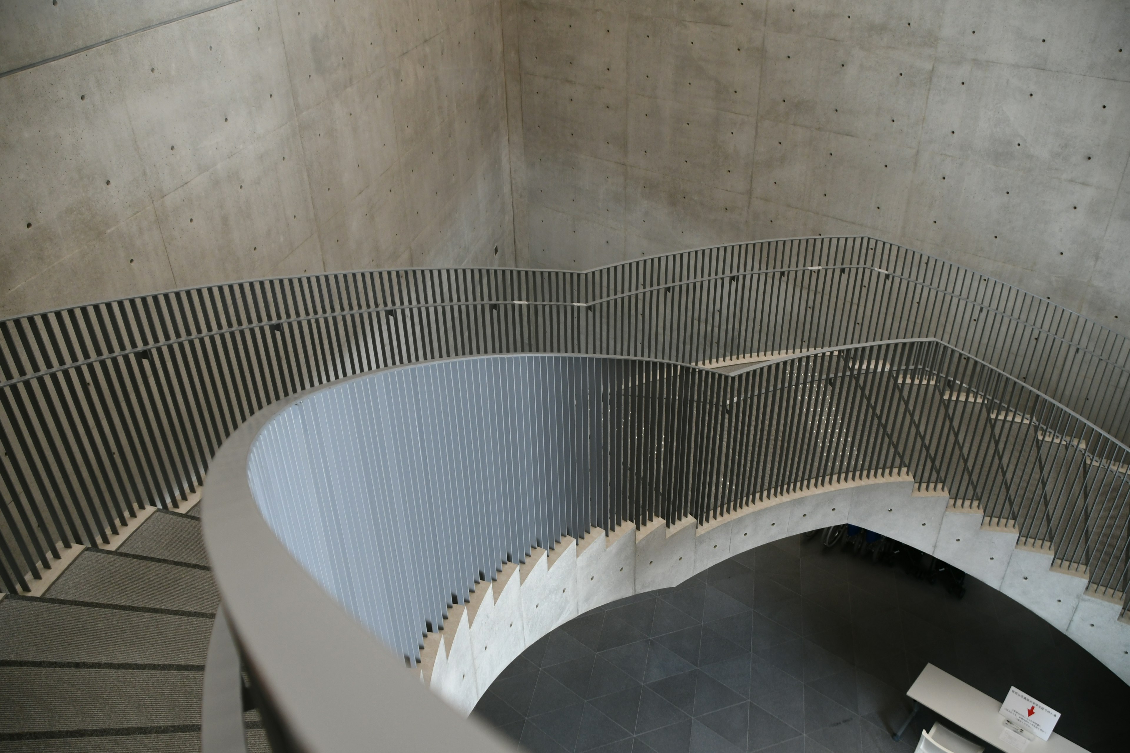 Vogelperspektive auf eine moderne Treppe mit glatter, geschwungener Geländer