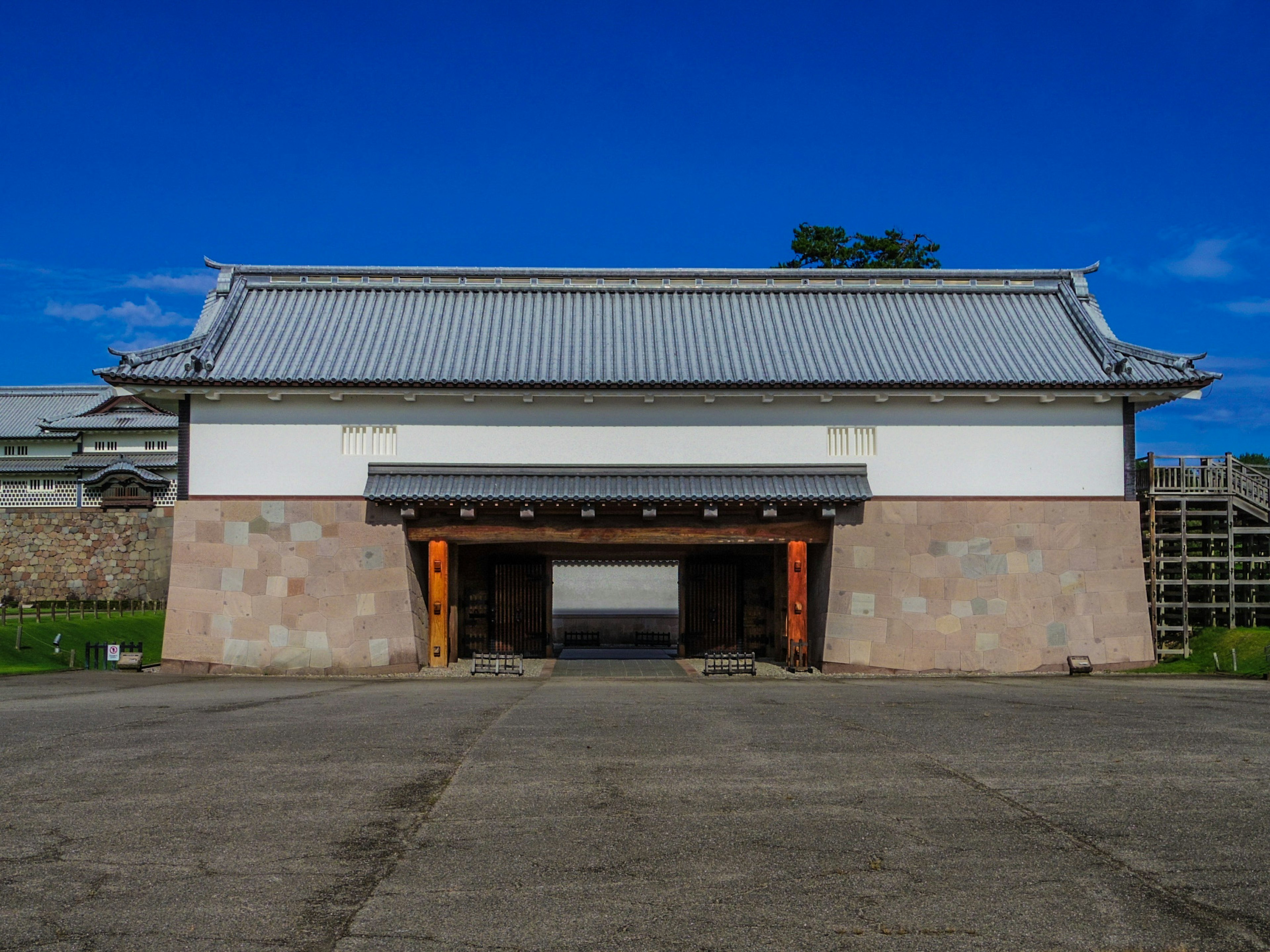 Photo of a Japanese gate with white walls and a traditional roof