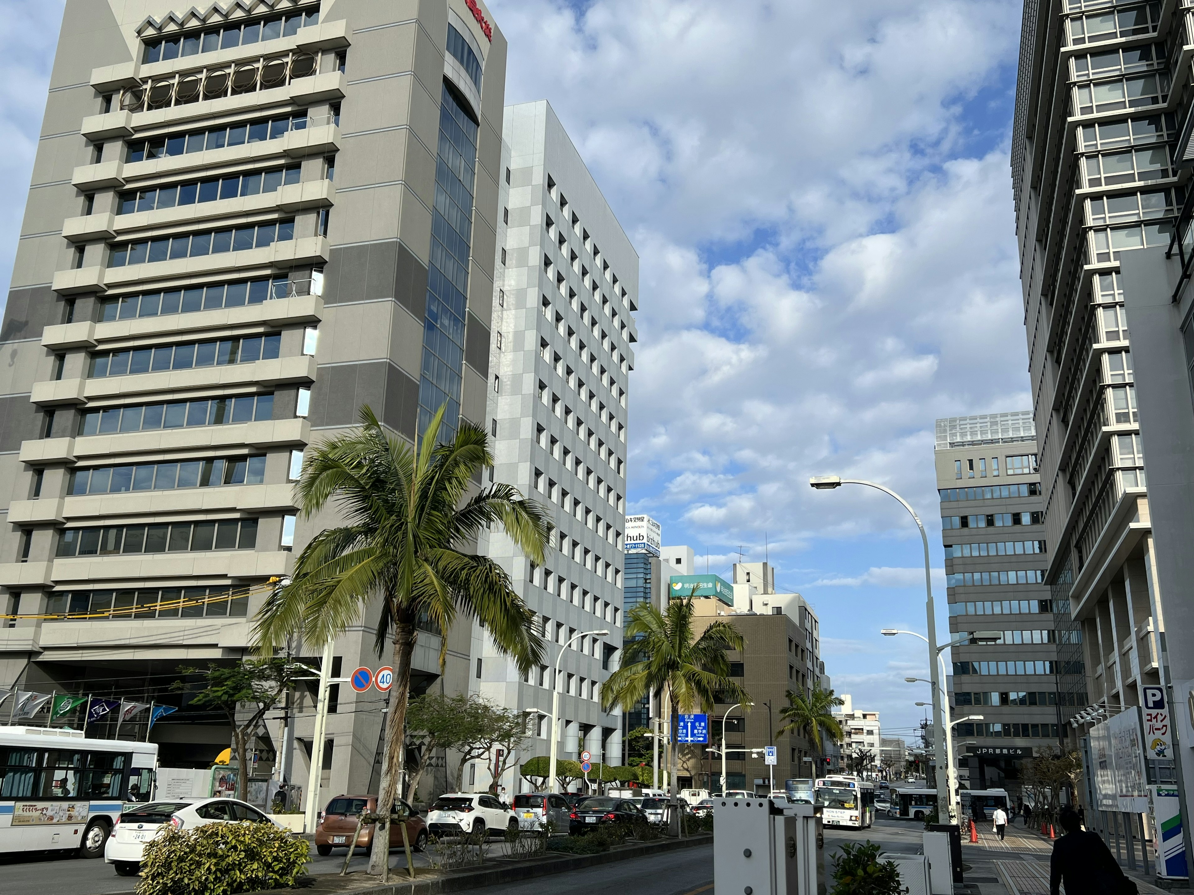 Stadtbild mit hohen Gebäuden unter blauem Himmel und Wolken