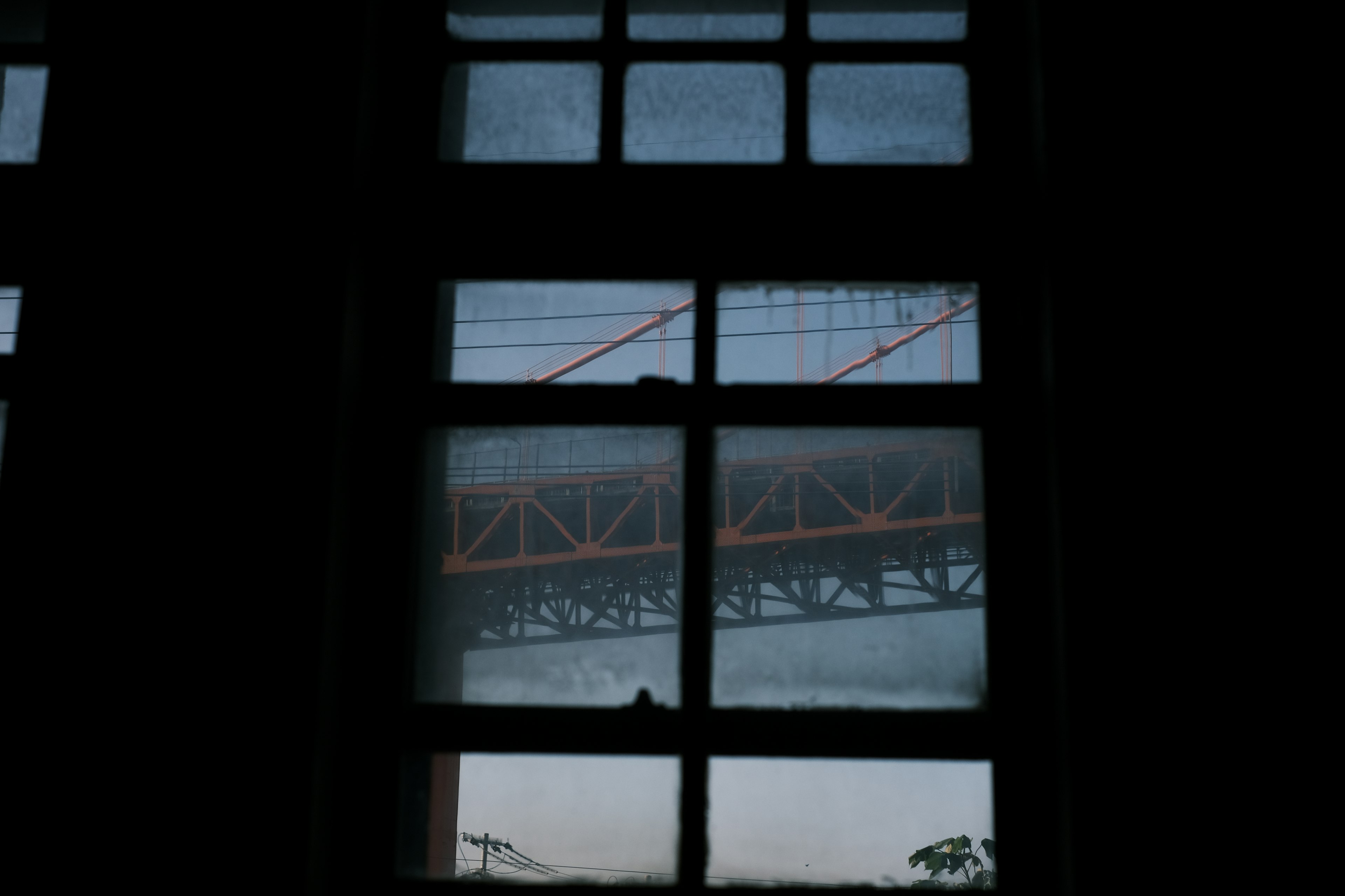 Blick auf eine orange Brücke durch ein Fenster