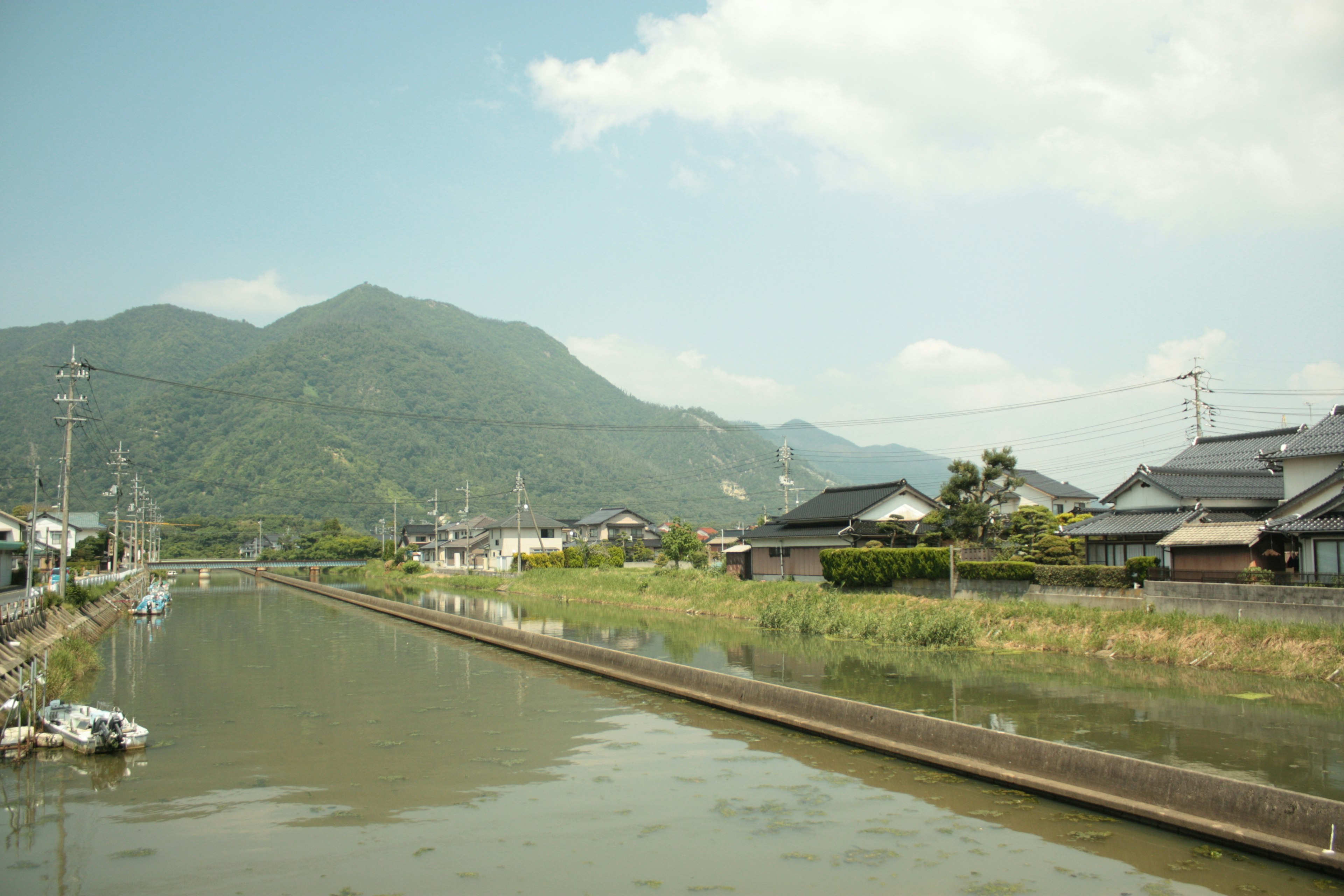 Un paysage serein d'un village japonais entouré de montagnes et d'une rivière