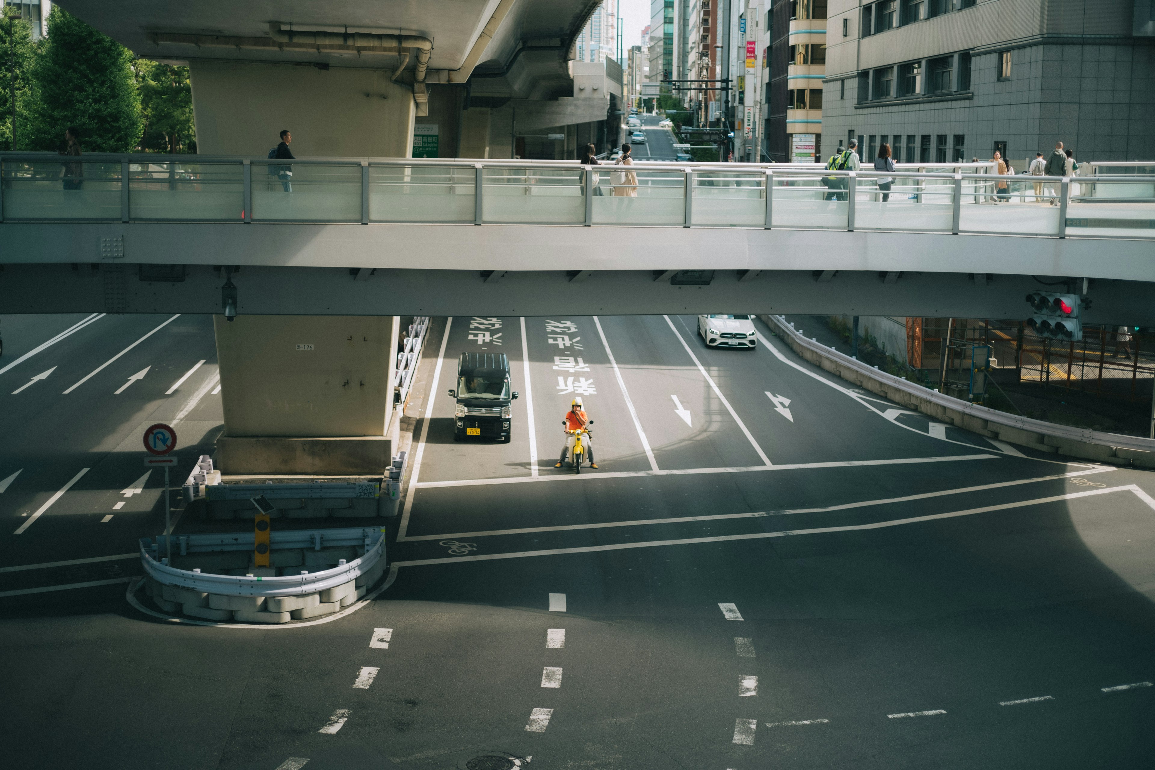 高架橋の下を走る車と二輪車の交通風景