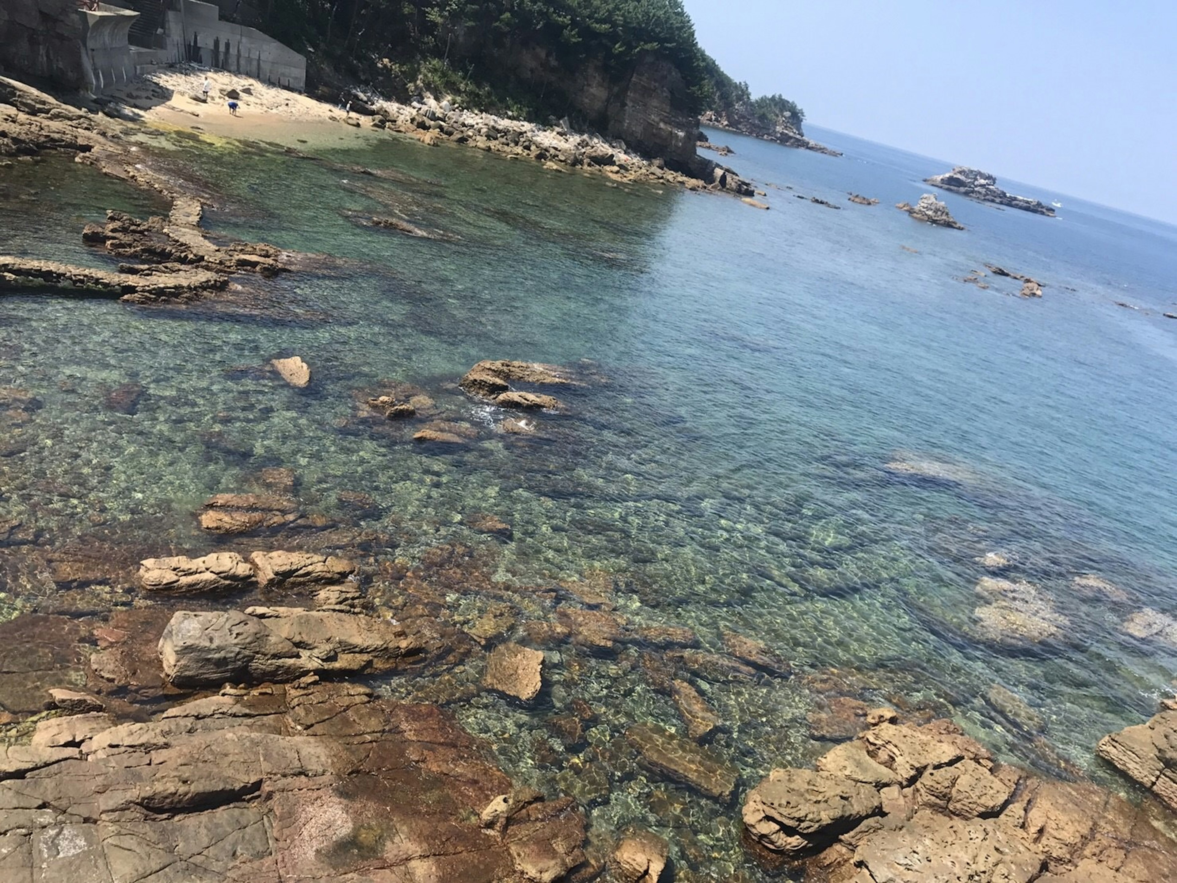 岩石海岸与清澈水域和远处岛屿