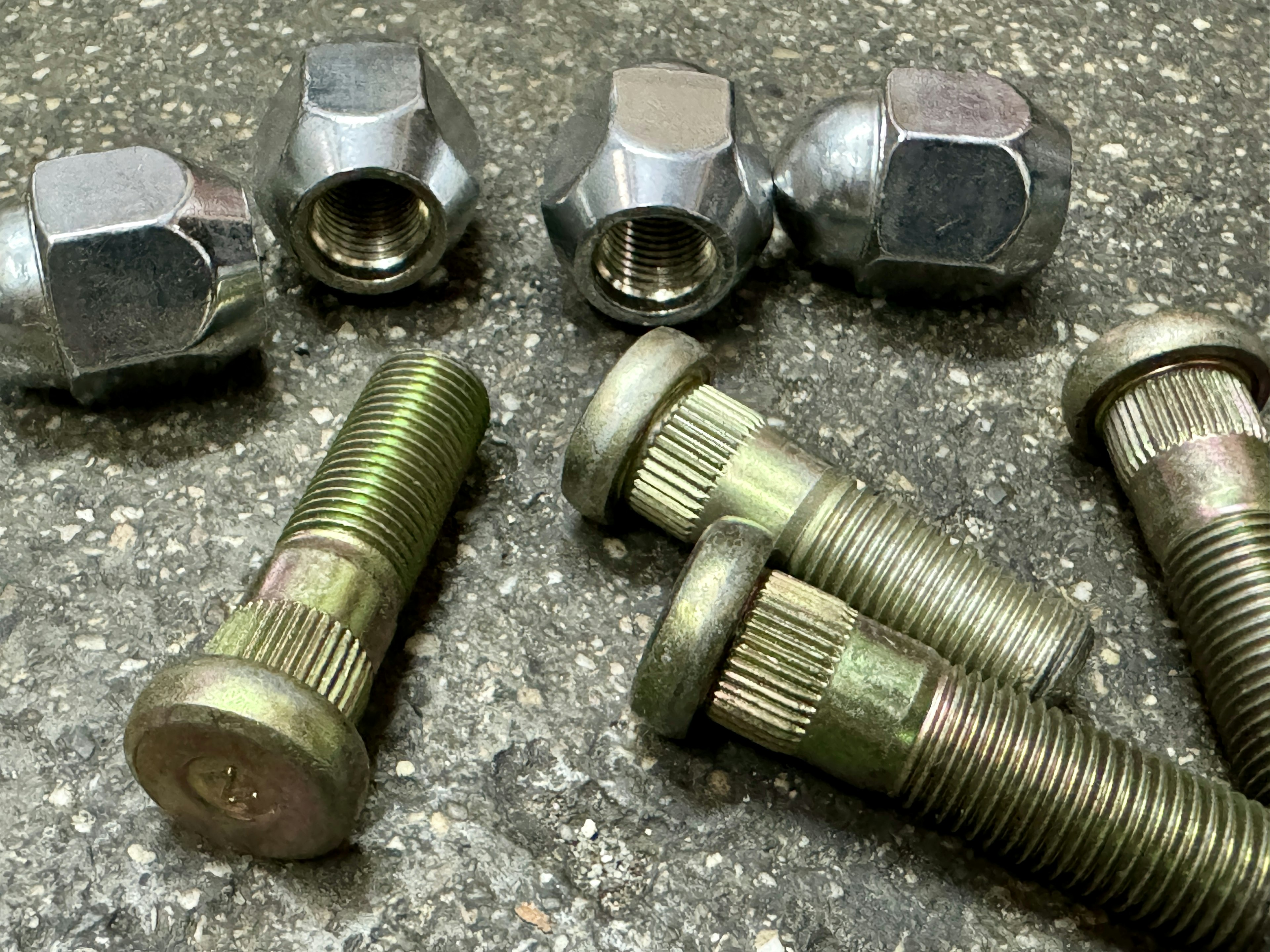 Metal bolts and nuts arranged on a surface