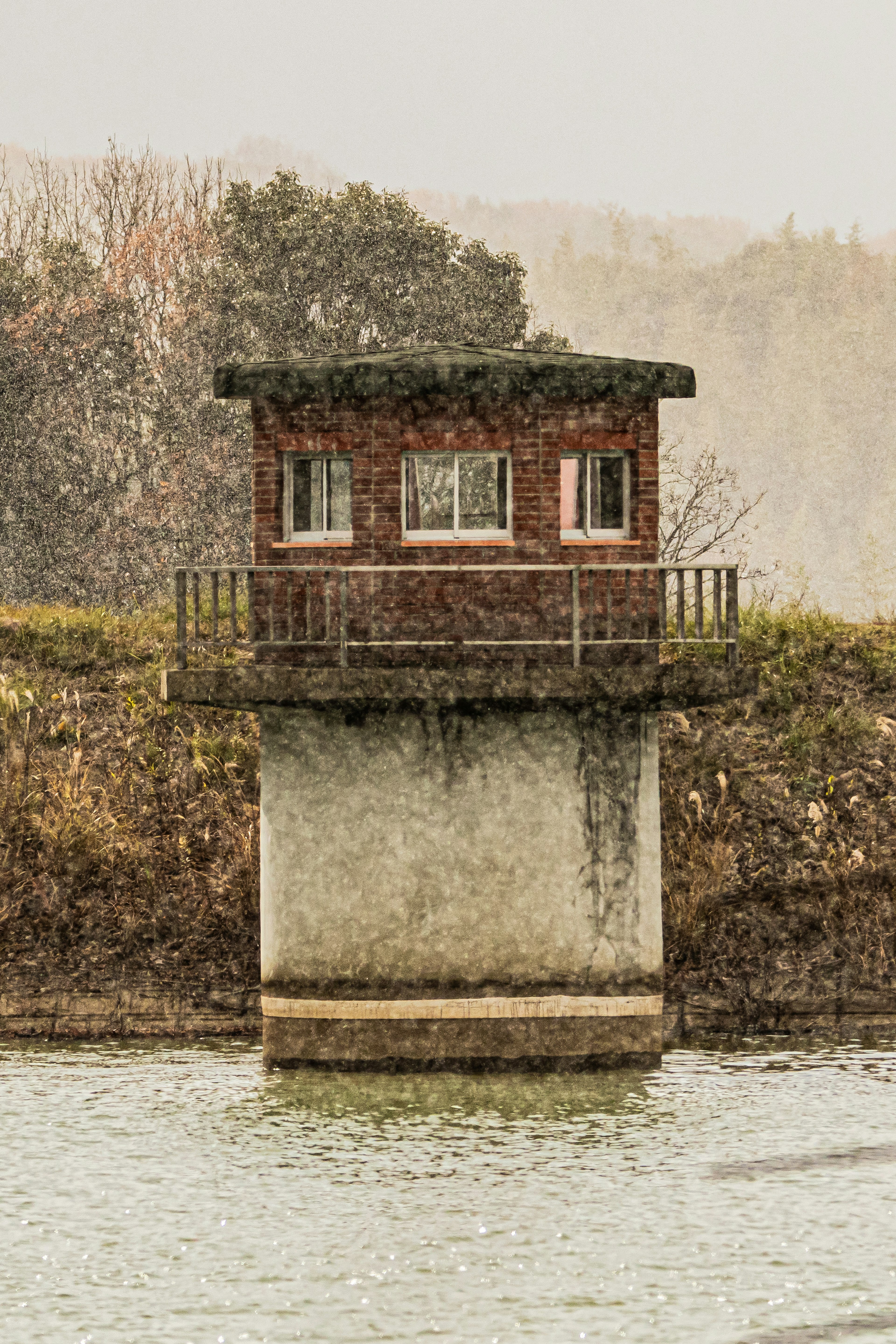 Small red building on a river surrounded by snow