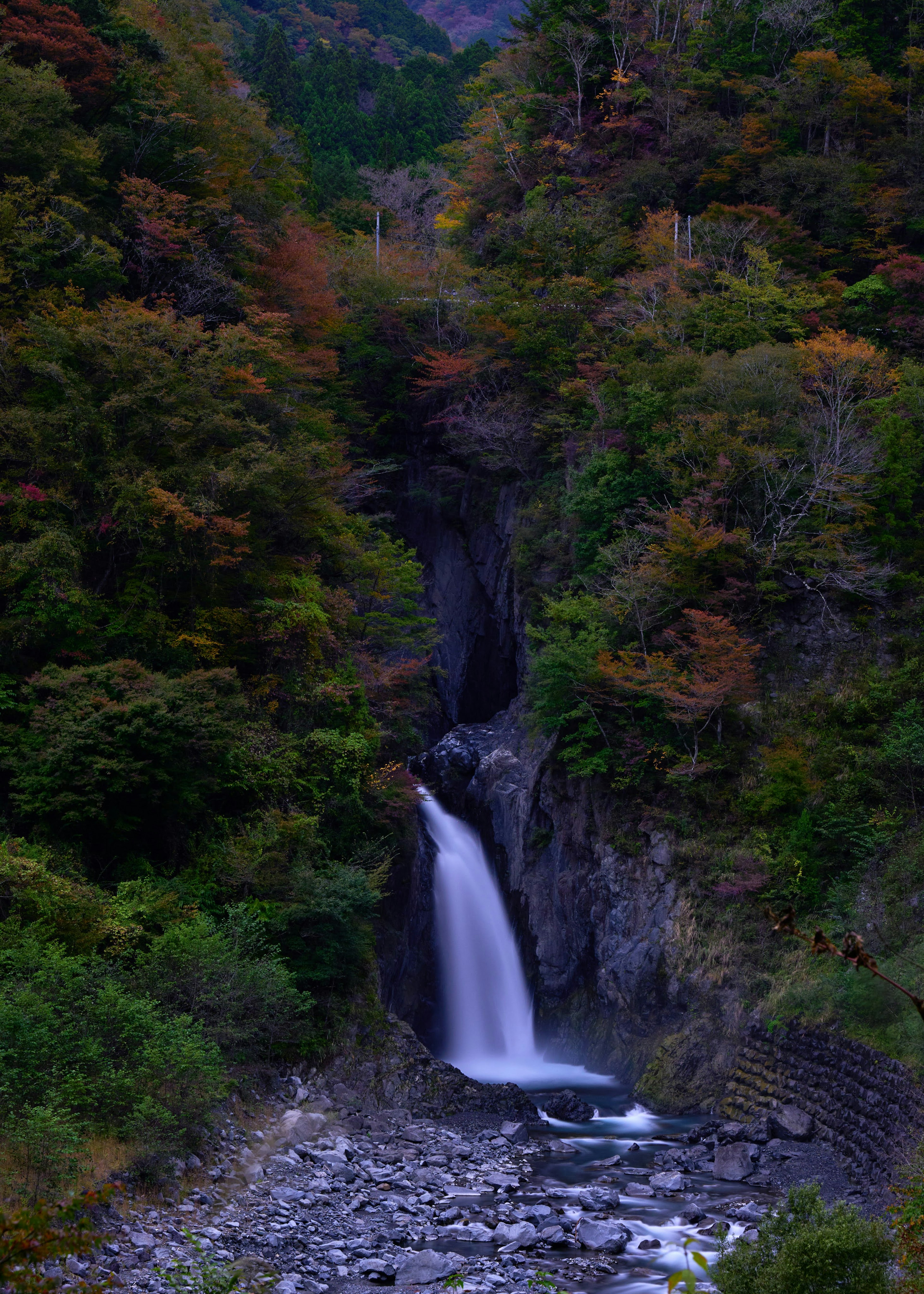 Malersicher Wasserfall umgeben von Herbstlaub