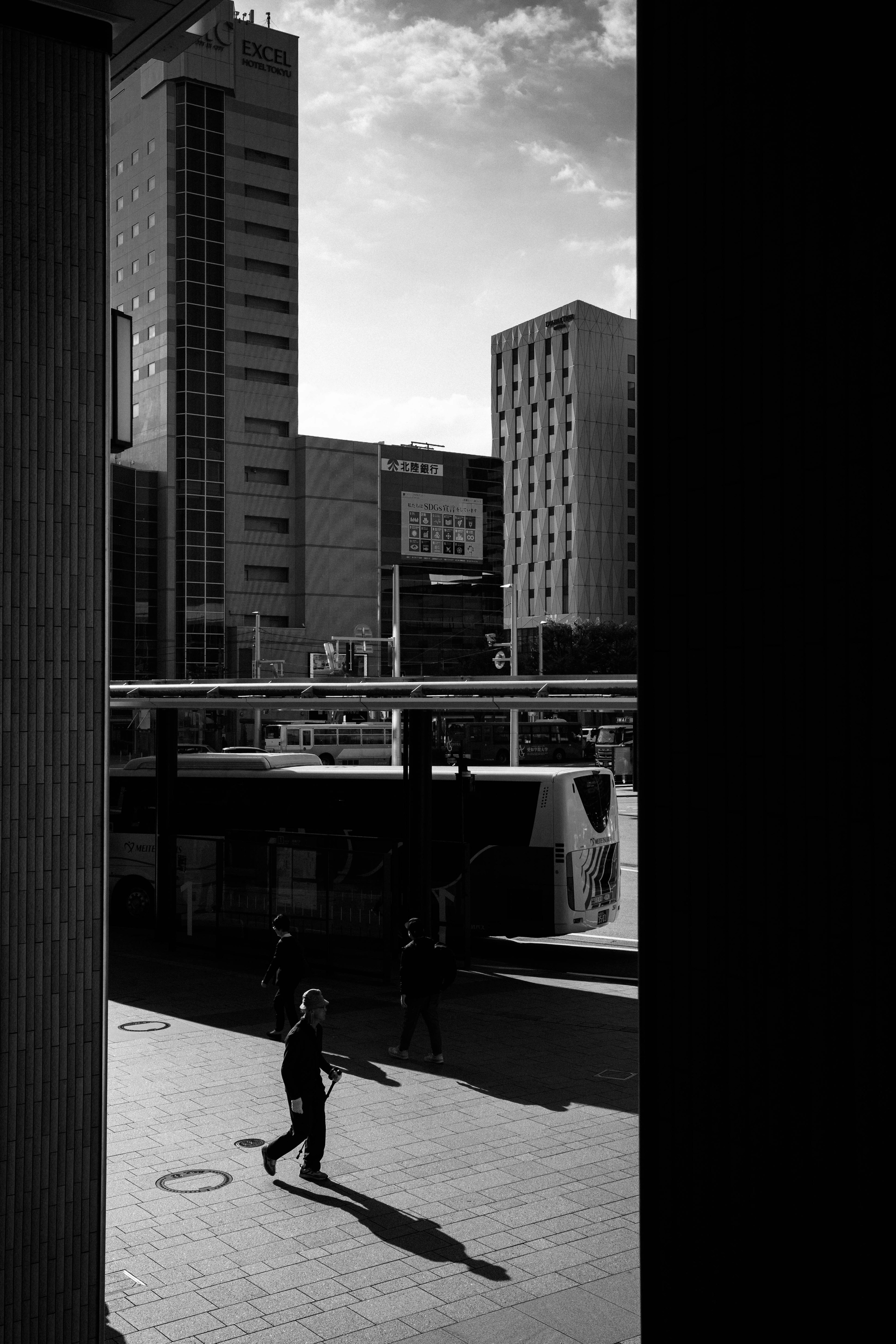 Foto in bianco e nero di una persona che cammina in un paesaggio urbano