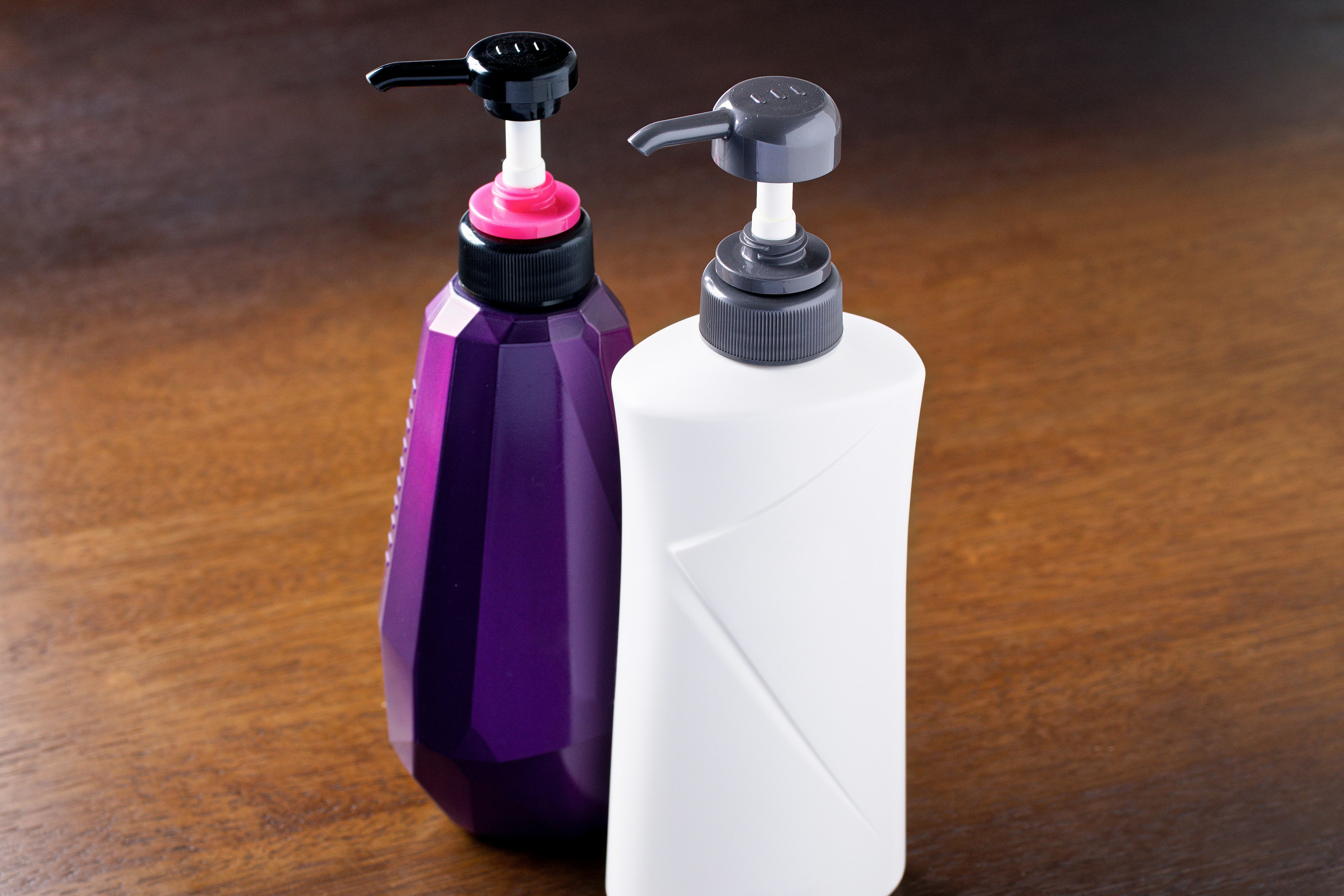 Purple and white pump bottles placed on a wooden table