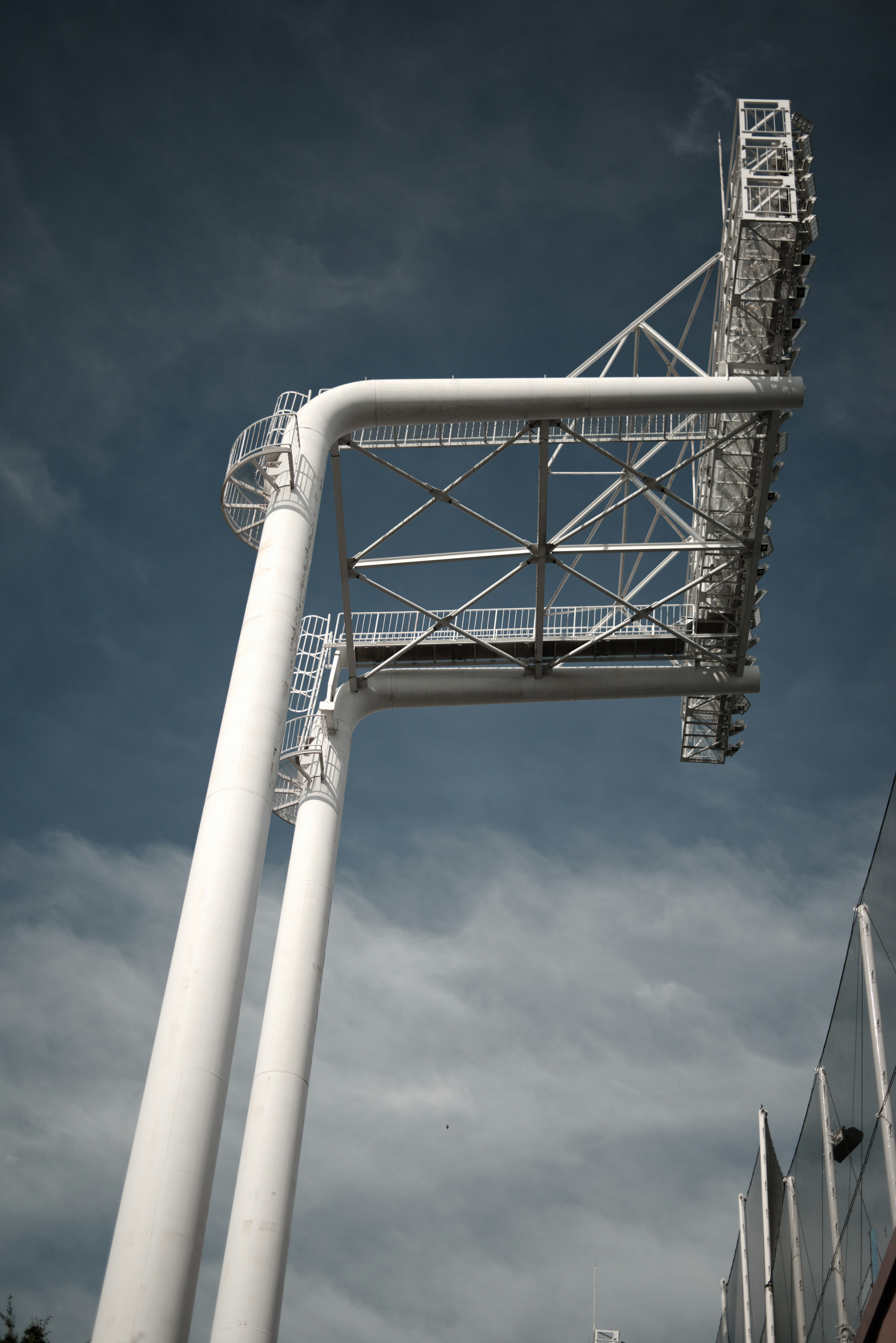 Image of a sports stadium sign viewed from below featuring white supports and a steel structure