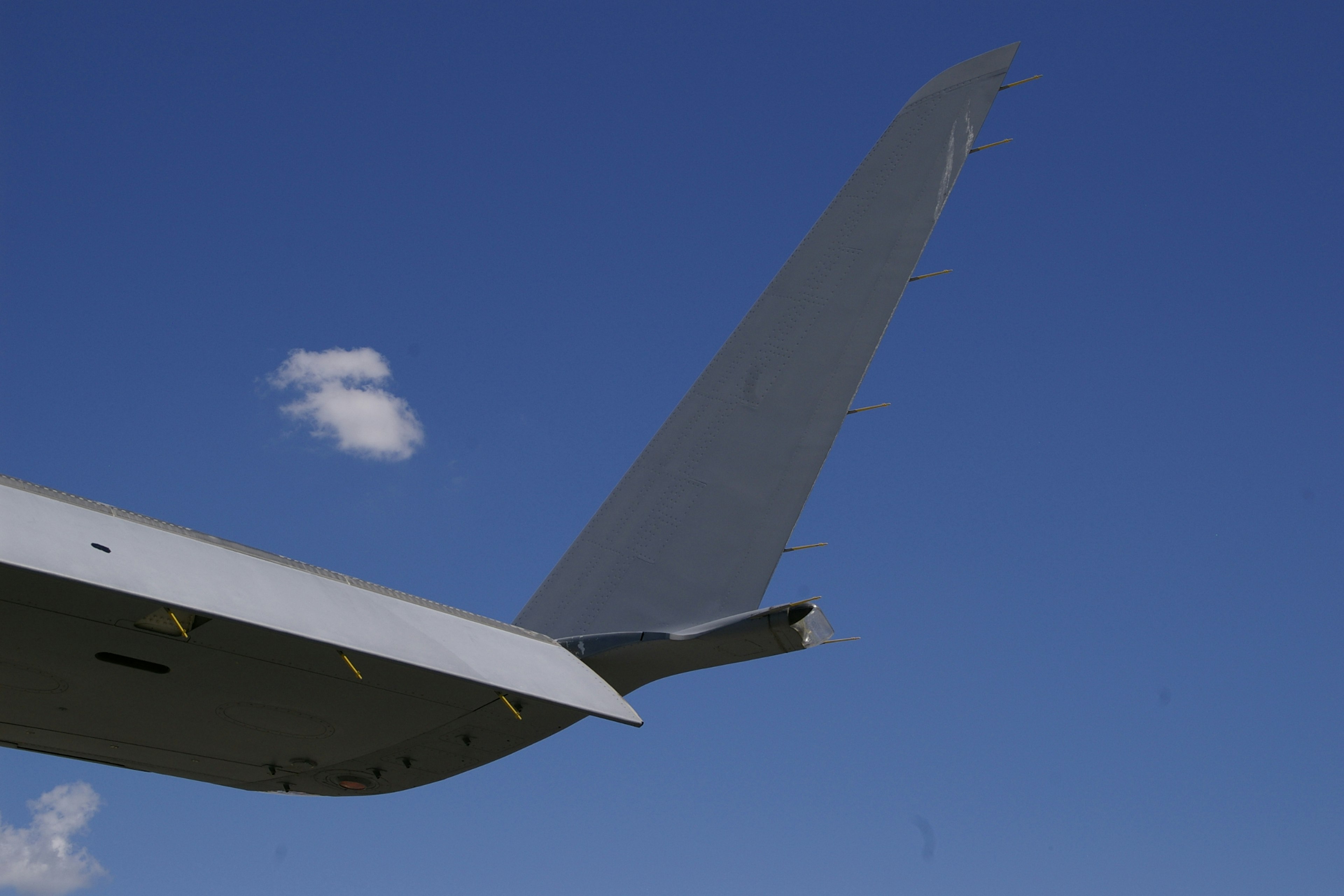 Aircraft tail fin against a clear blue sky