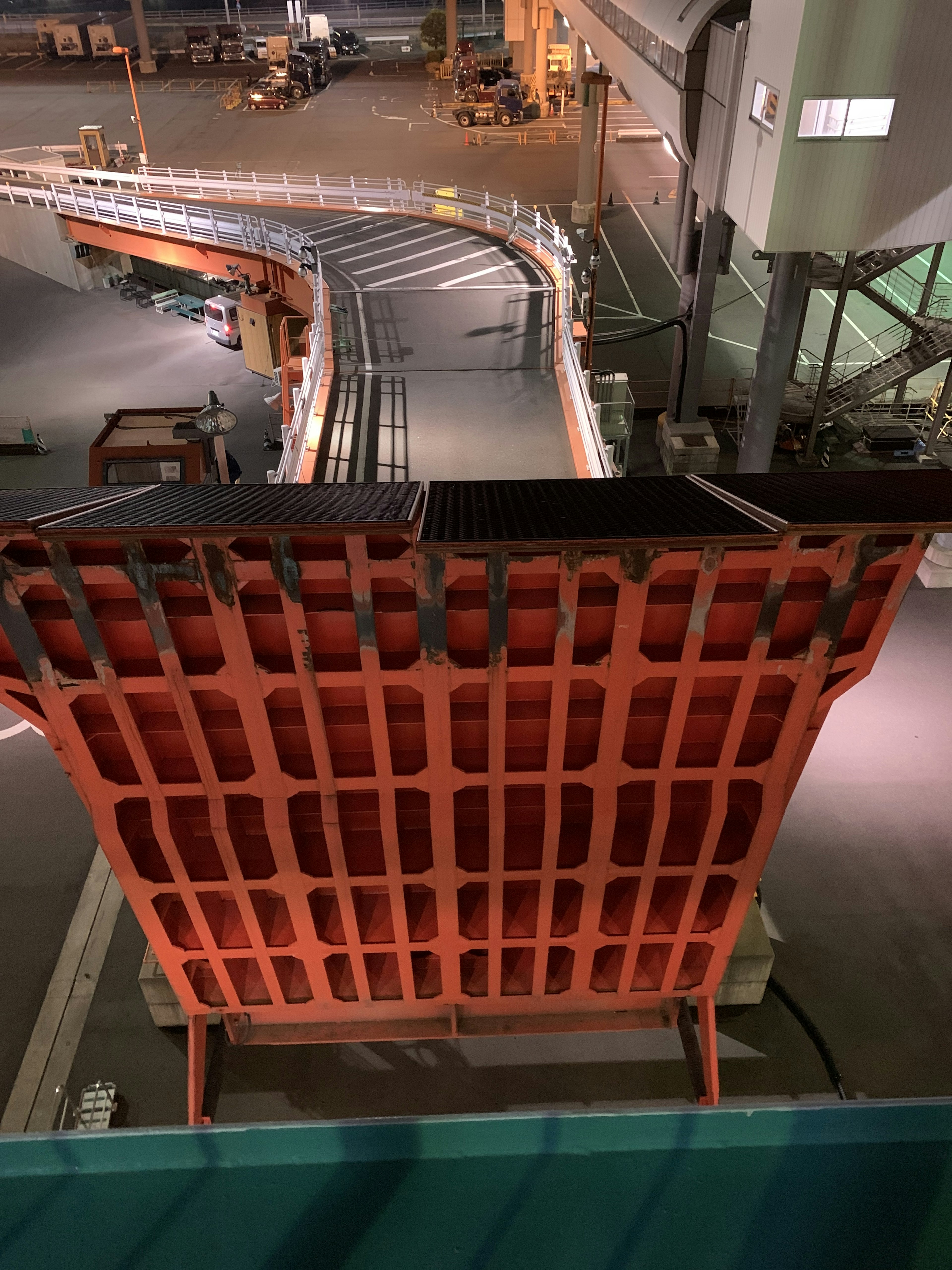 View from above of an orange grid structure over a factory conveyor belt