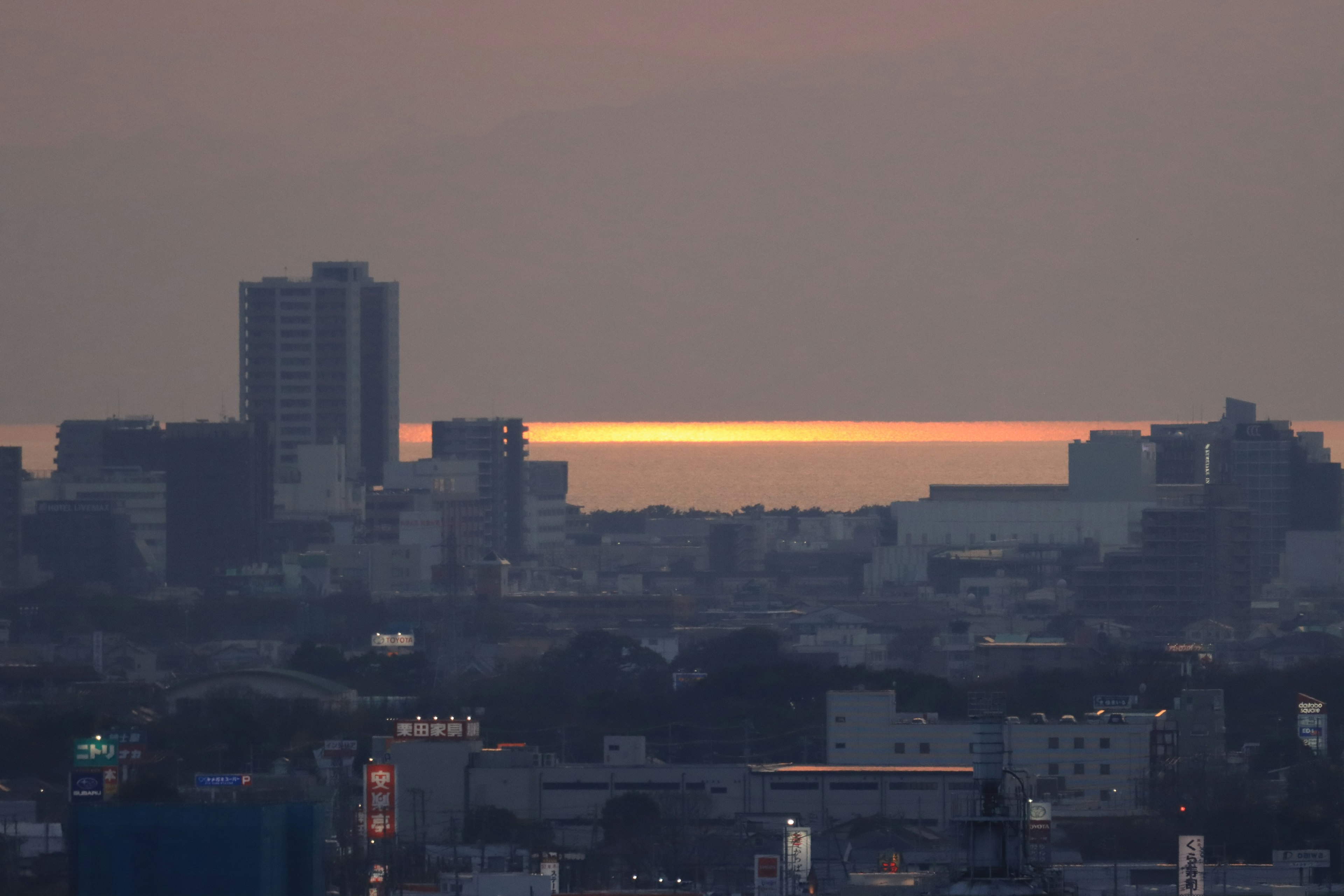 夕焼けが海に映る都市の景色