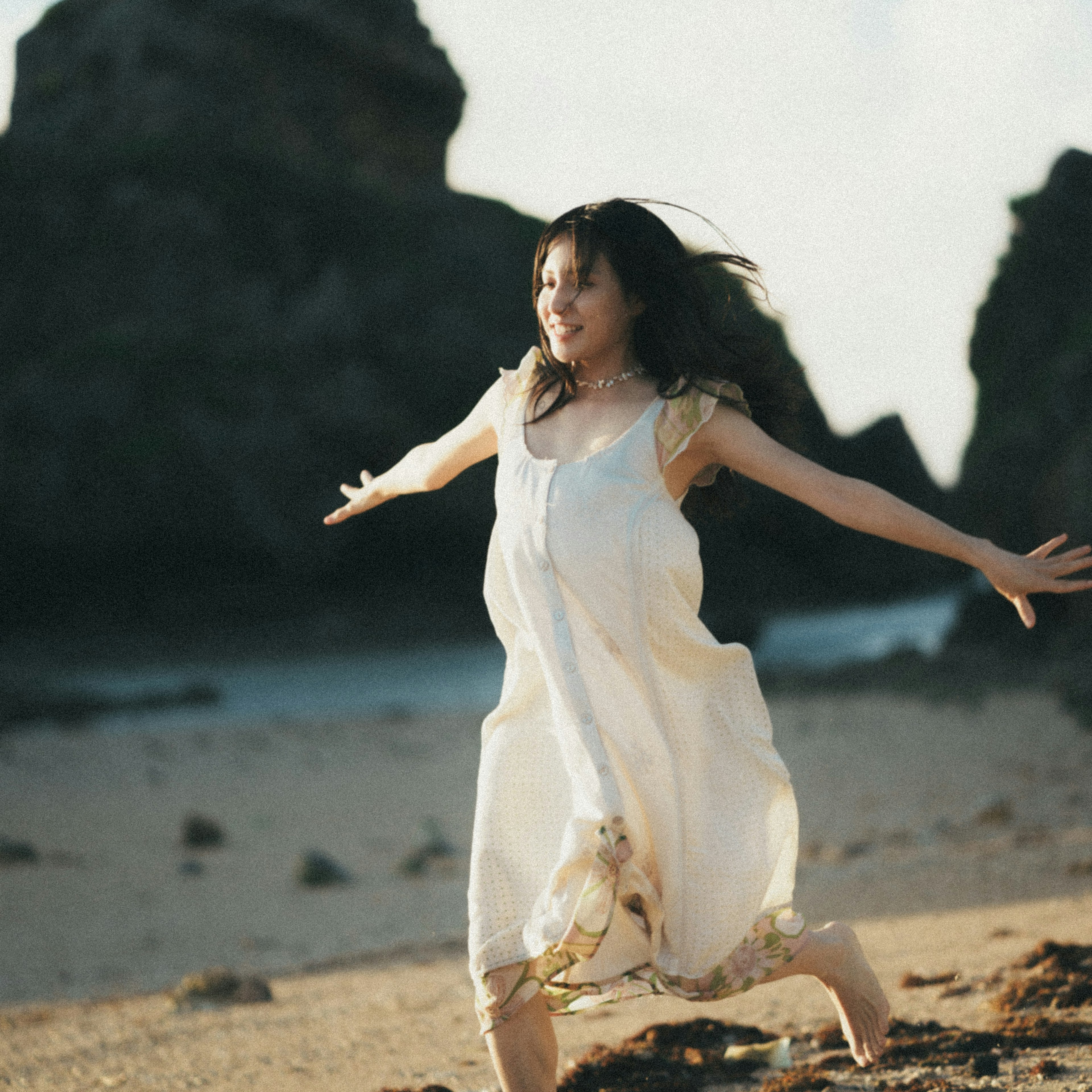 Una mujer con un vestido blanco corriendo alegremente en la playa